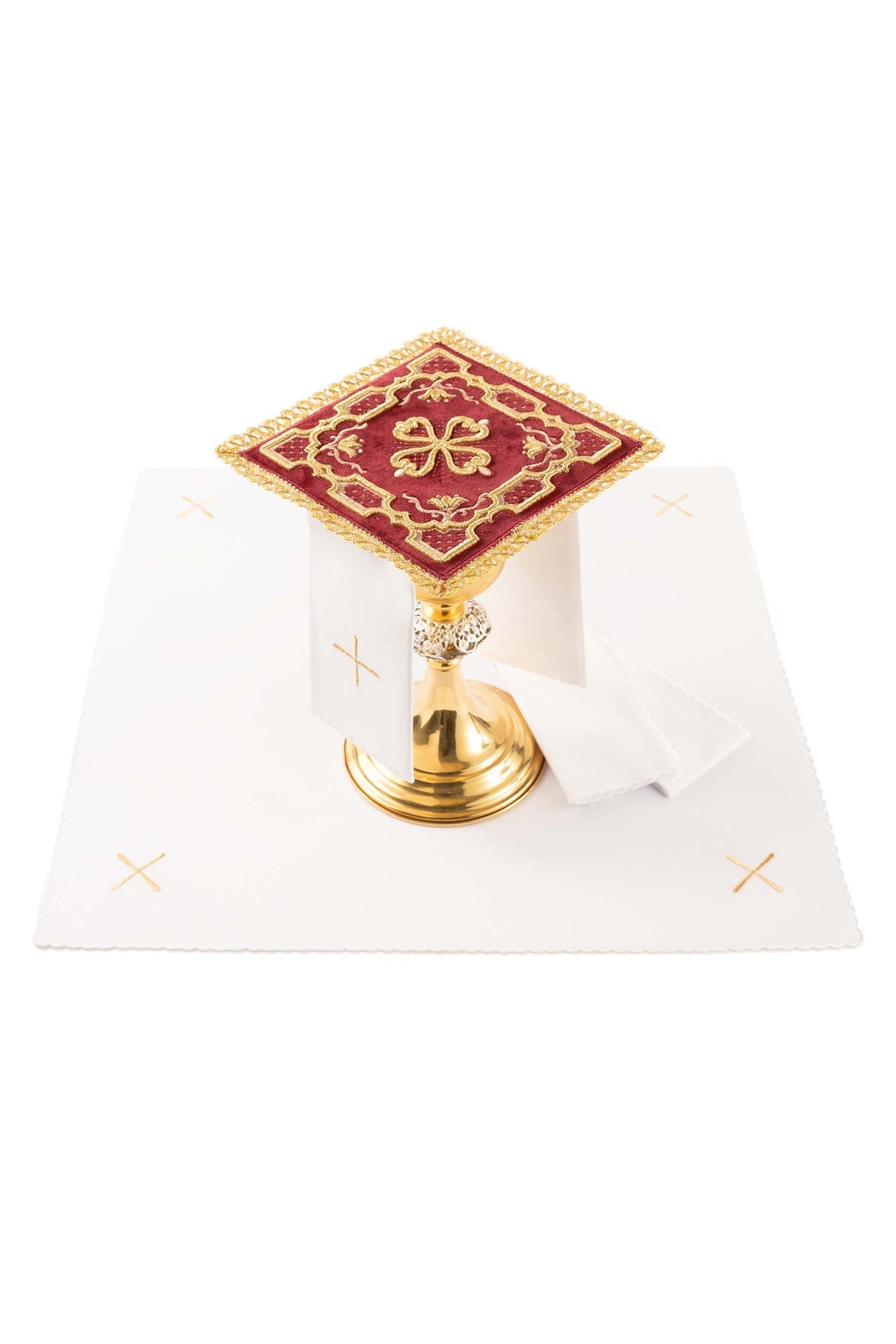Conjunto de alfaias litúrgicas vermelho: pala de veludo com bordado de cruz rosácea sobre um cálice dourado, corporal branco com cruzes, sanguíneo e manutérgio