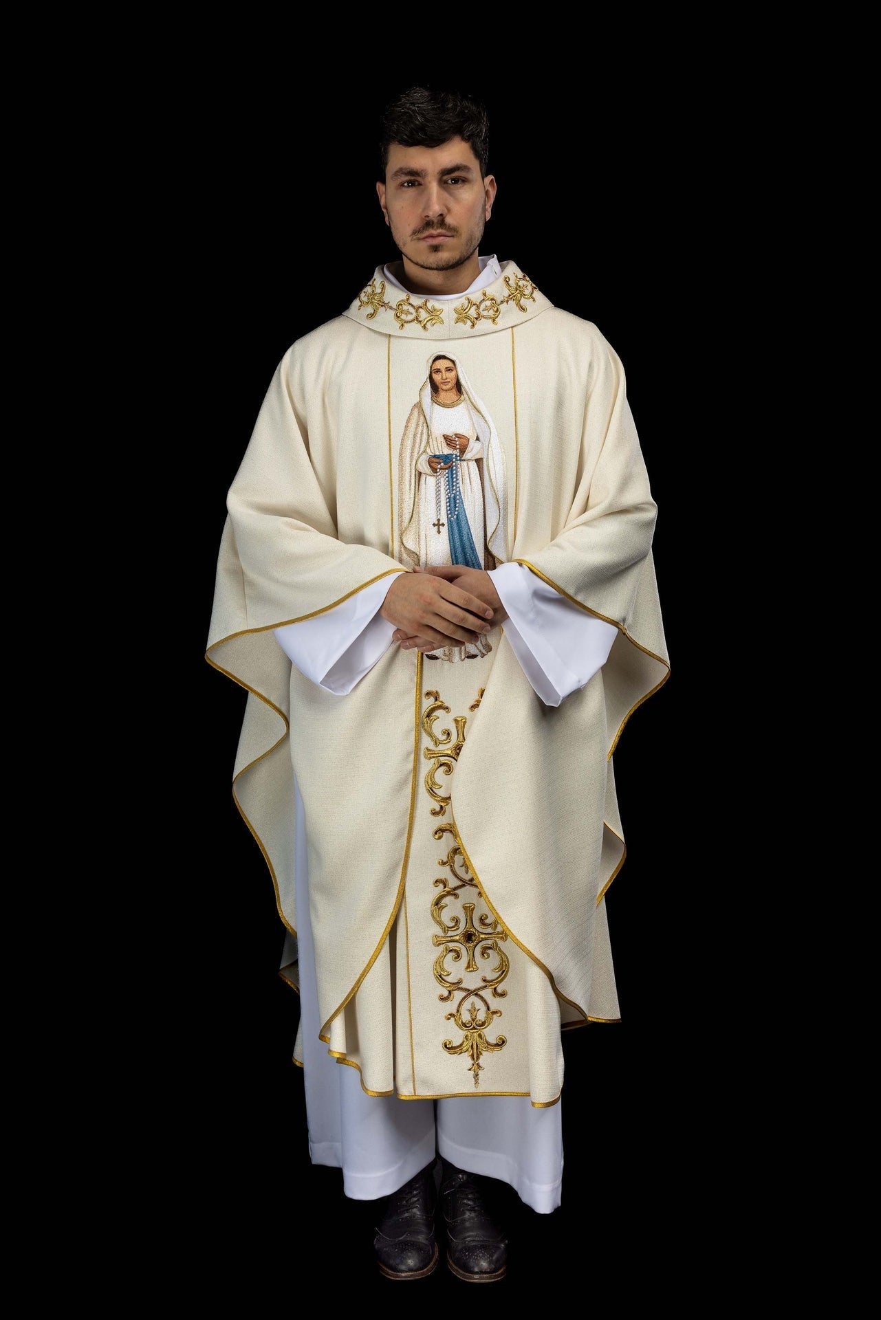 Casula creme com bordado de Nossa Senhora do Rosário e detalhes dourados.