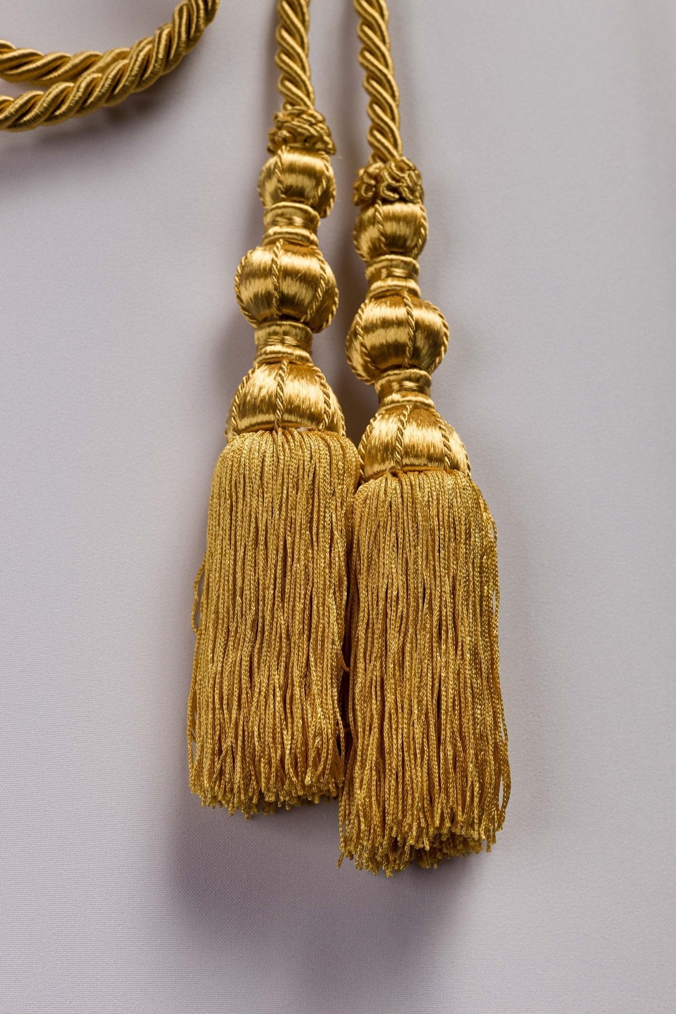 Cíngulo litúrgico dourado amarrado em uma alva branca