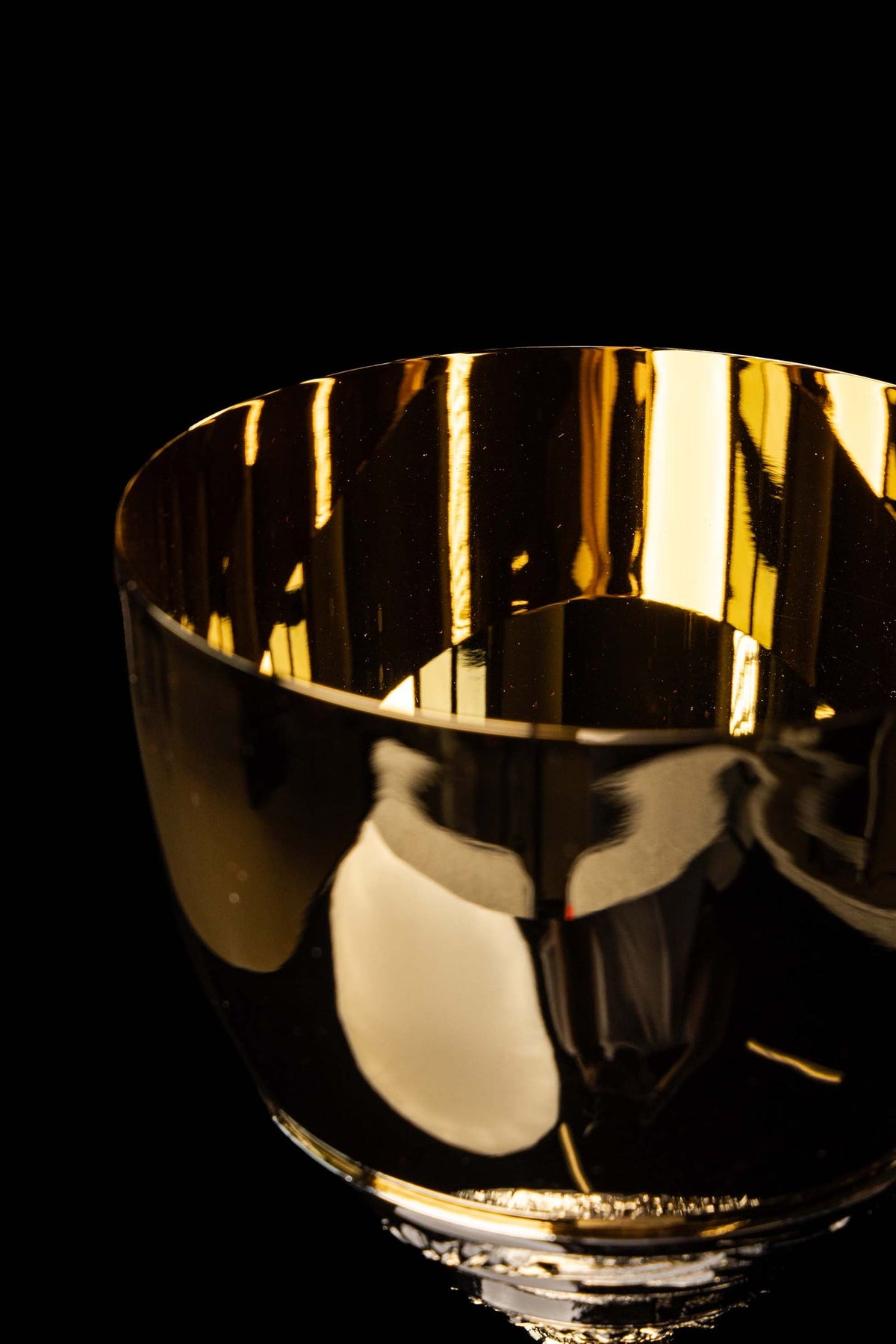 Cálice litúrgico com copa dourada e borda lisa em close-up