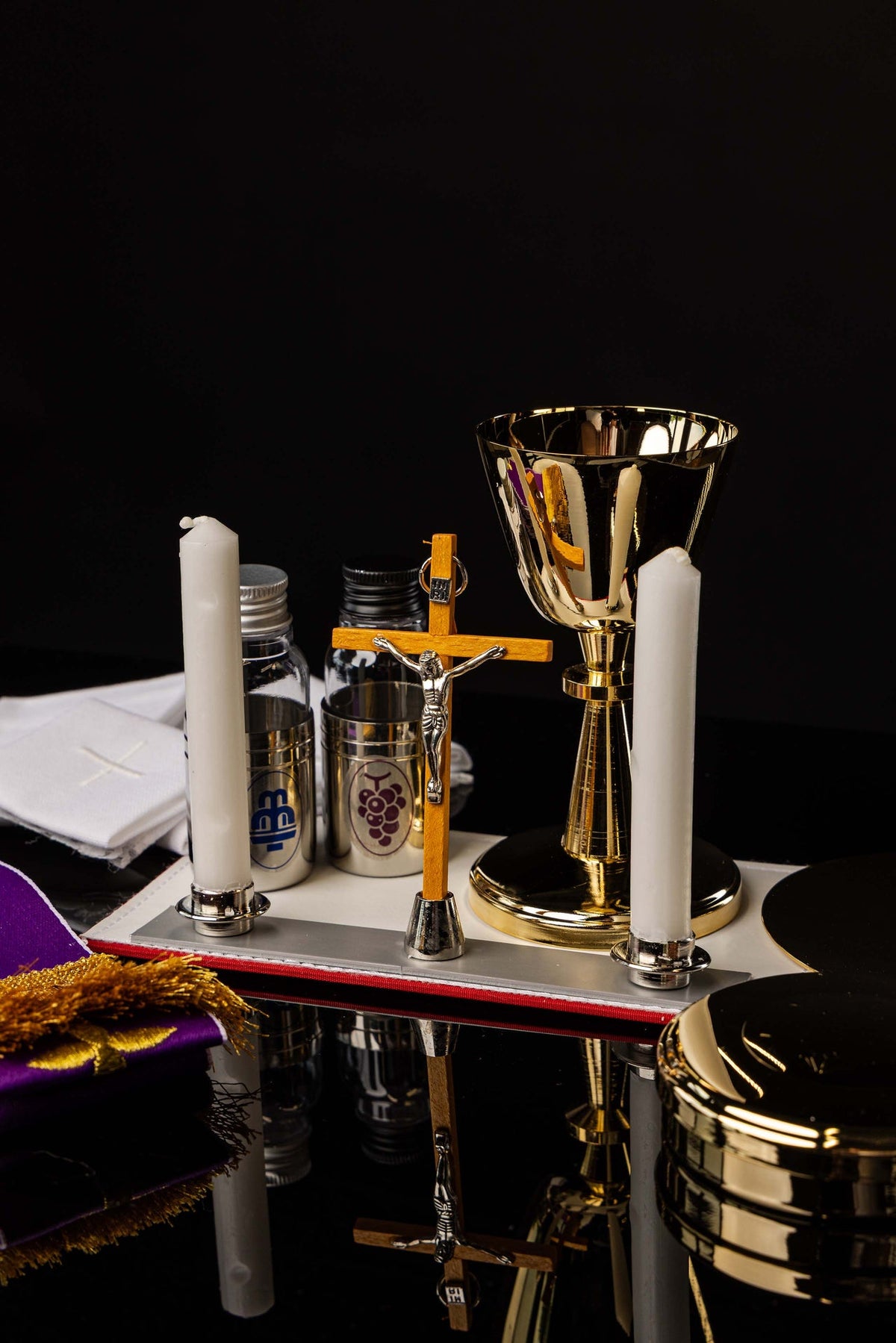 Equipamento litúrgico da maleta missionária, com cálice litúrgico, velas, cruz e galhetas