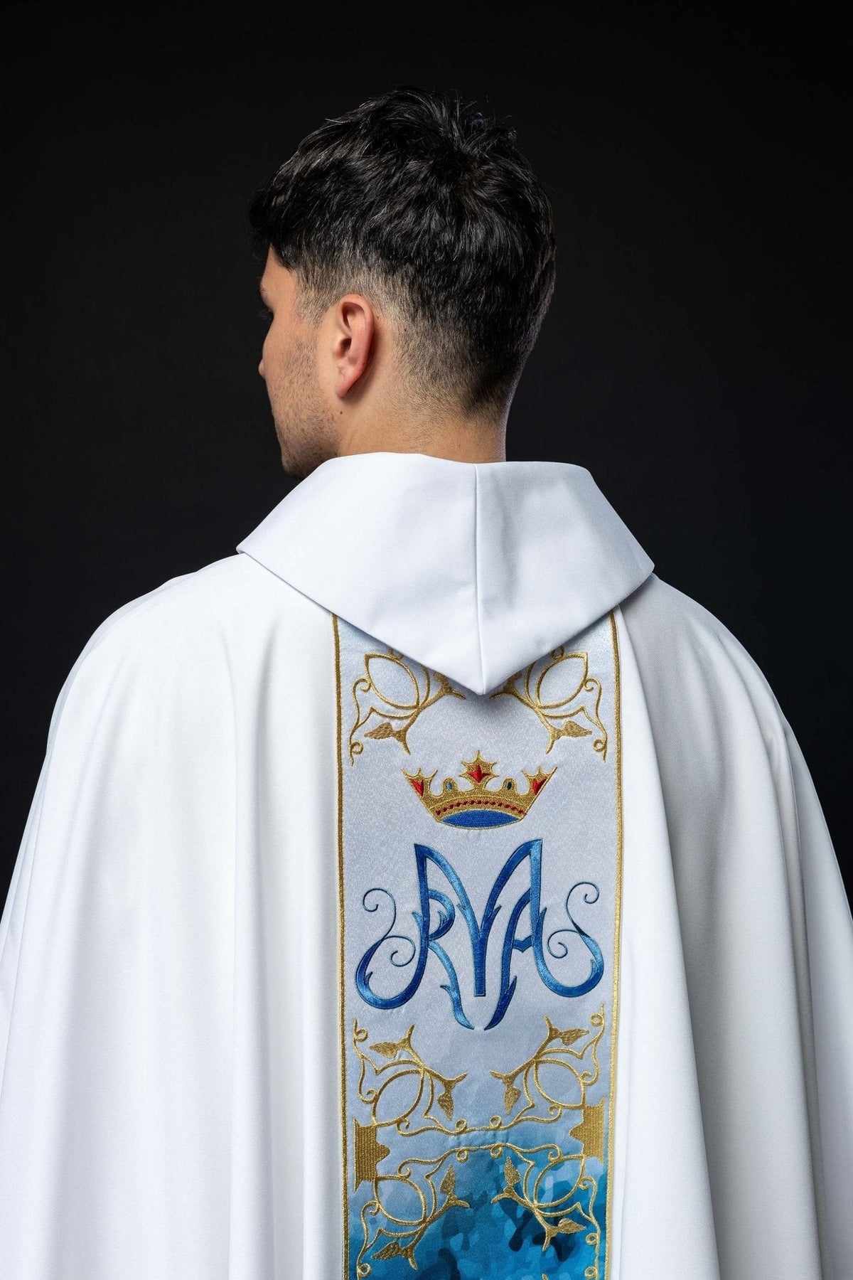 Detalhe superior da casula mariana, com coroa bordada e monograma azul na faixa