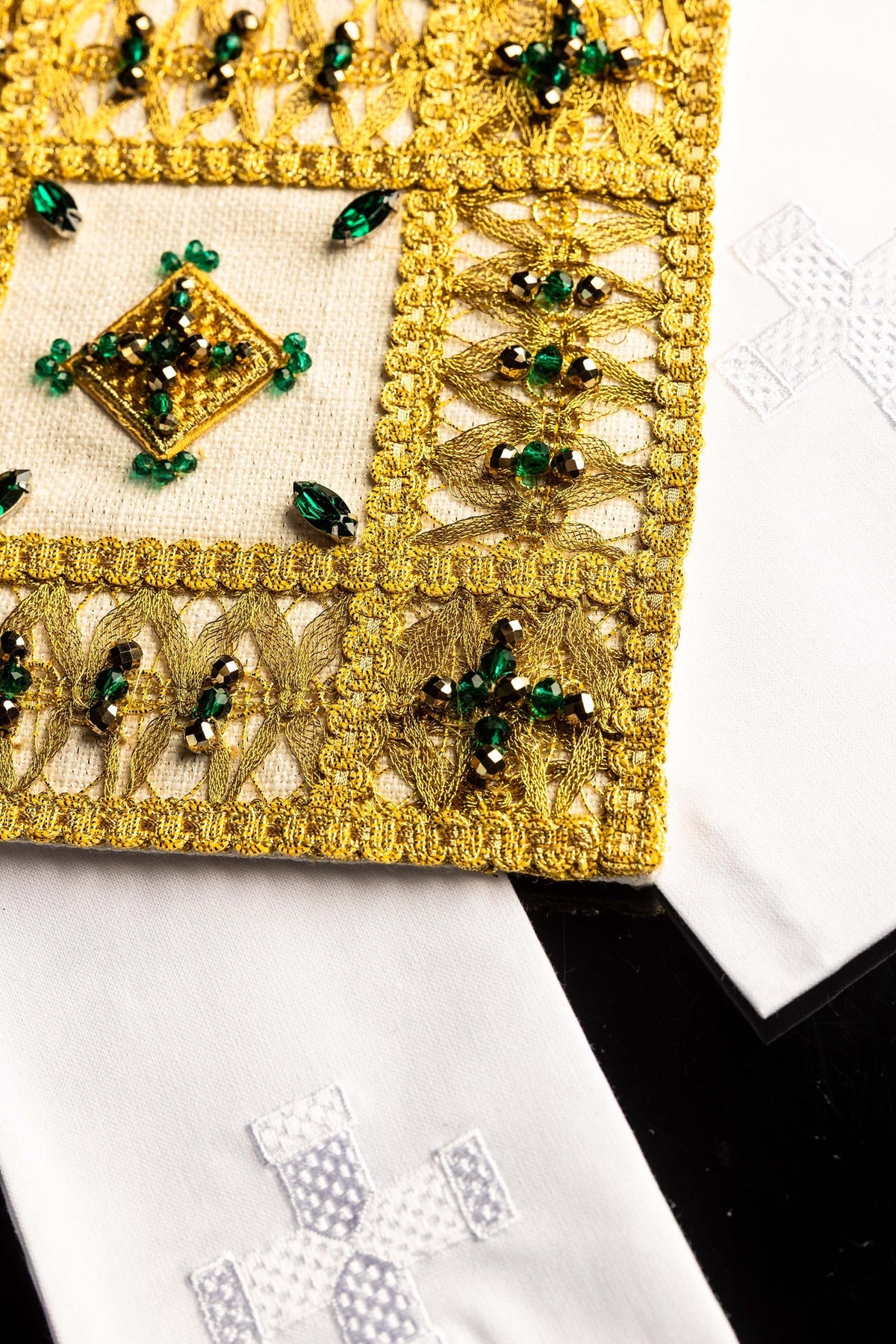 Conjunto de alfaias litúrgicas, detalhe lateral do bordado dourado sobre tecido branco