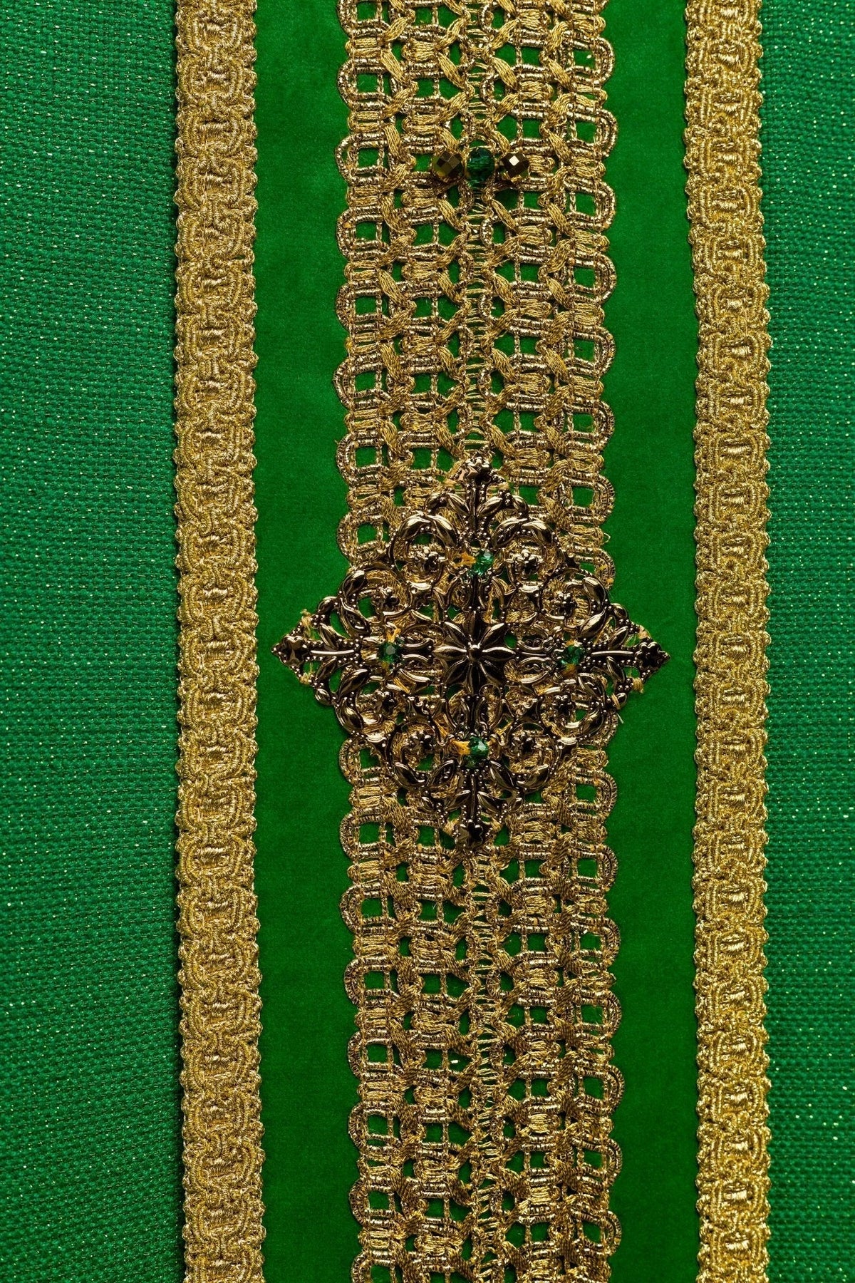 Casula verde artesanal em close-up do aplique floral dourado e faixa central