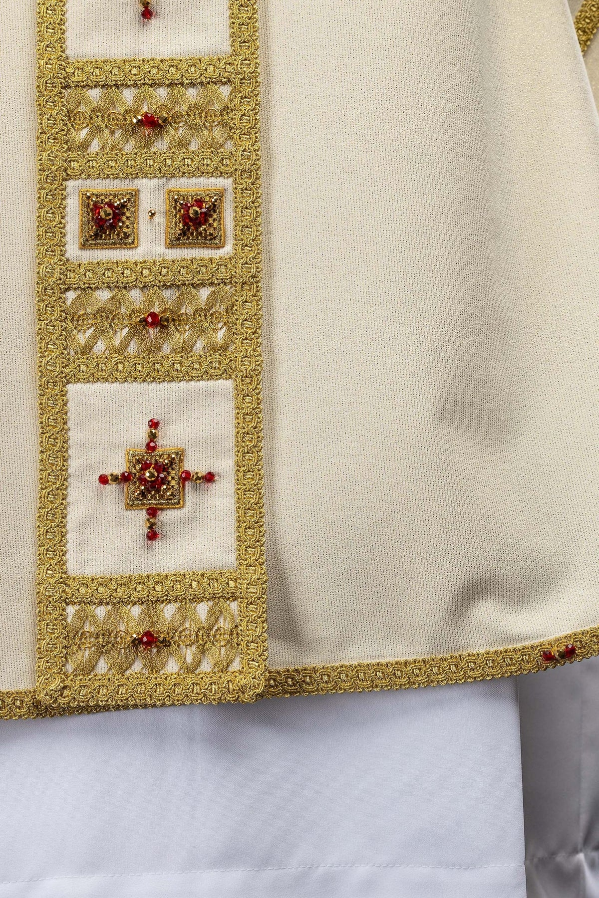 Casula artesanal em detalhe da manga com acabamento dourado e aplicação de pedras