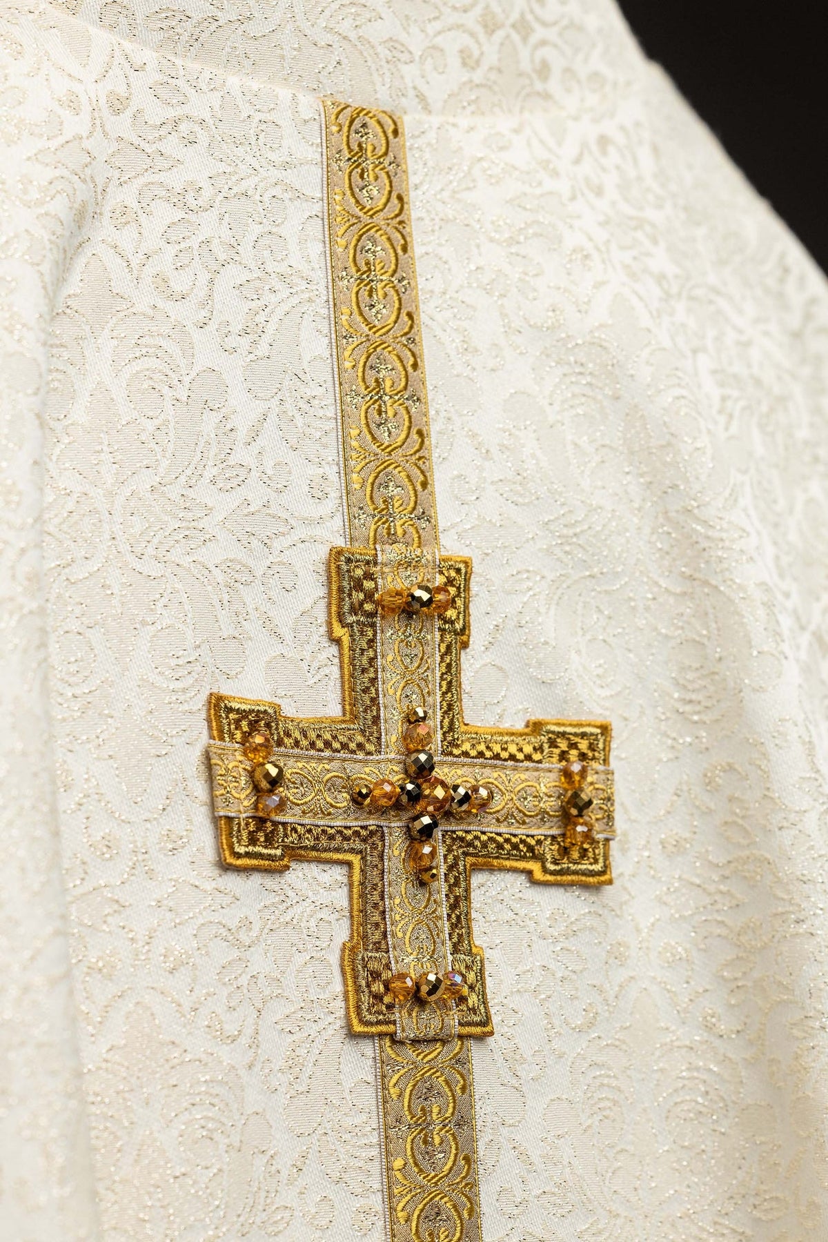 Casula marfim em close, tecido jacquard floral e galão dourado no ombro