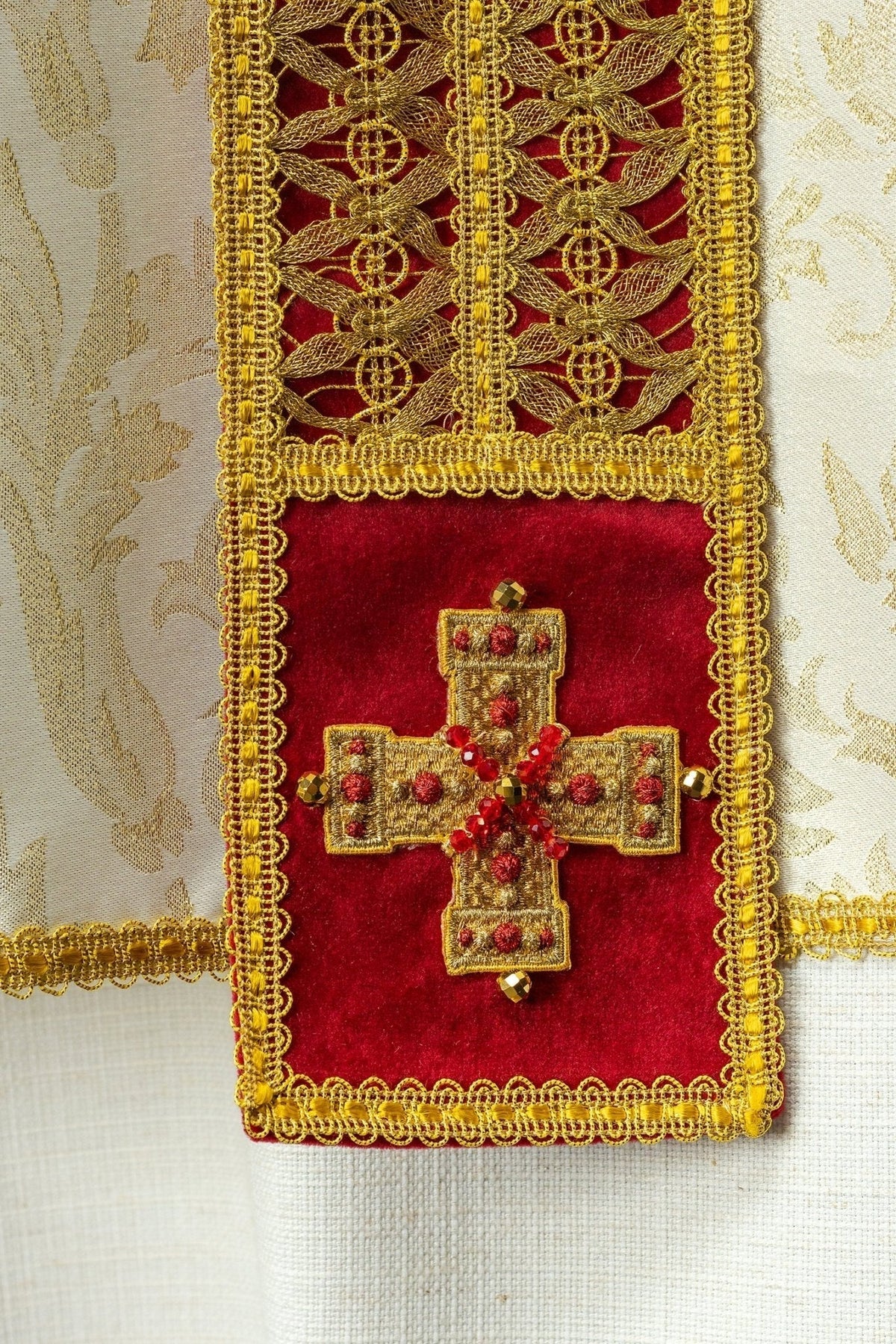 Casula artesanal, detalhe da cruz dourada com pedras vermelhas na faixa frontal
