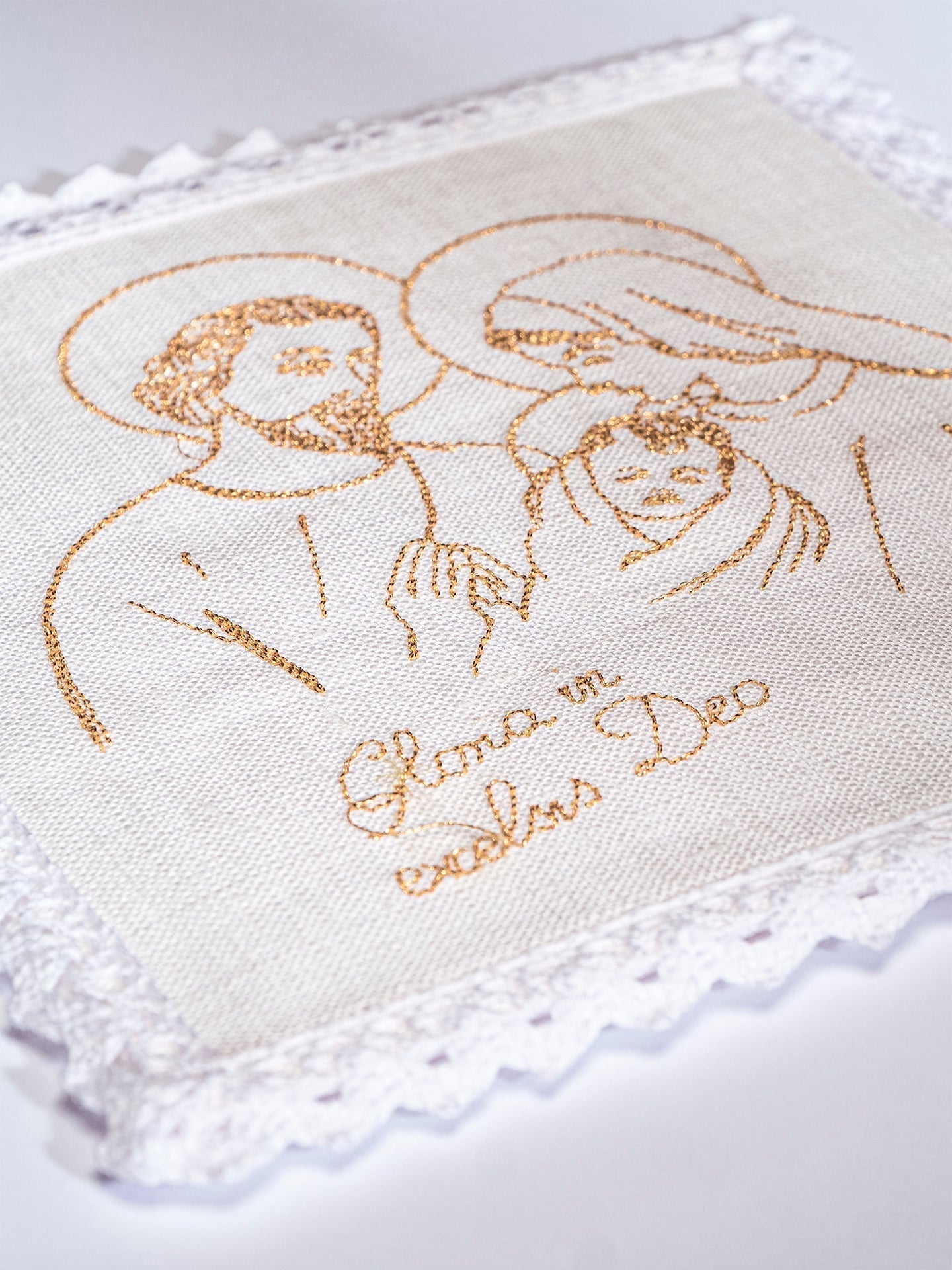 Conjunto de alfaias litúrgicas em linho branco, bordado com a Sagrada Família e cruzes douradas, para o Natal.