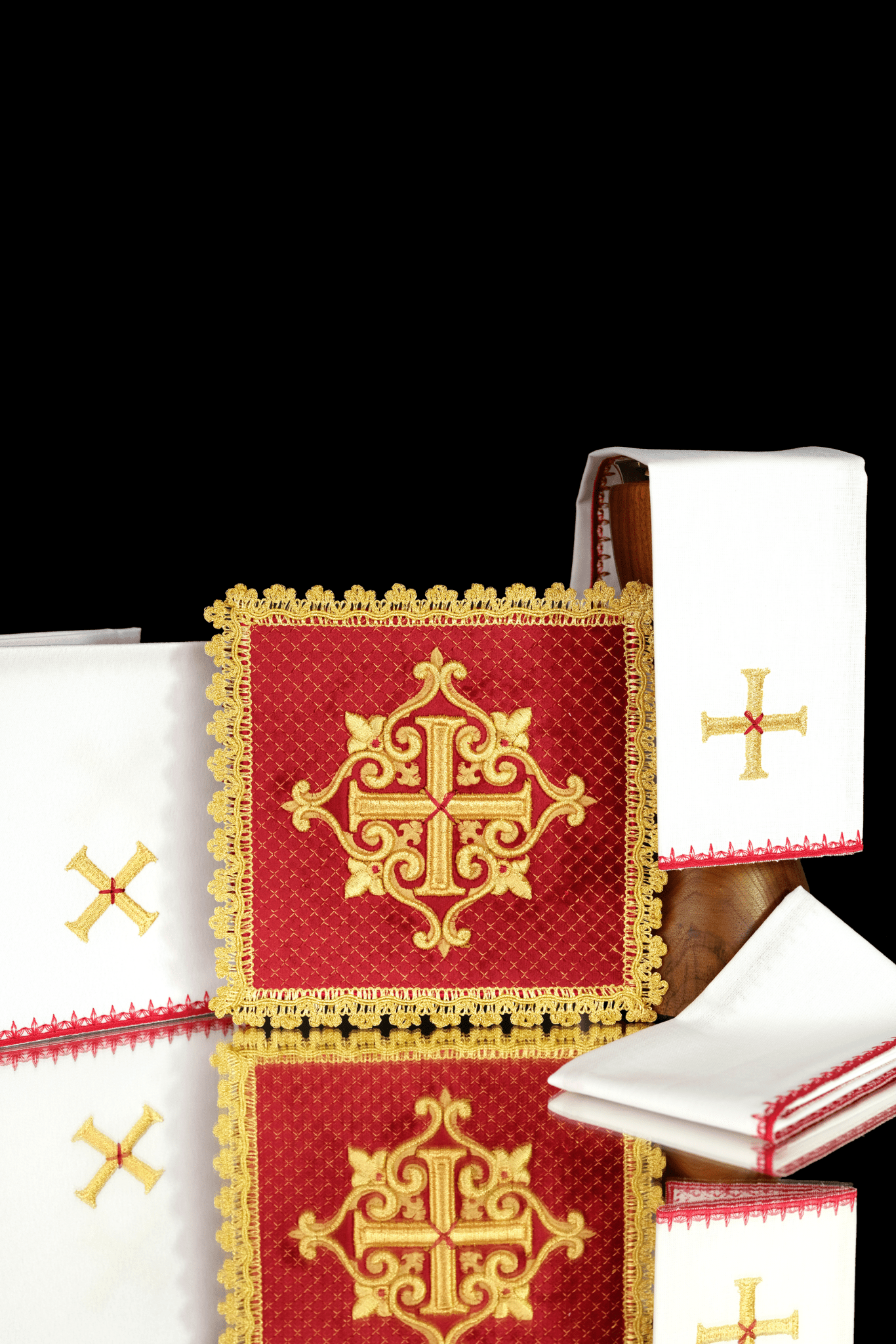 Conjunto de alfaias litúrgicas vermelho com cruz dourada bordada em veludo, incluindo pala, corporal, sanguíneo e manustérgio.