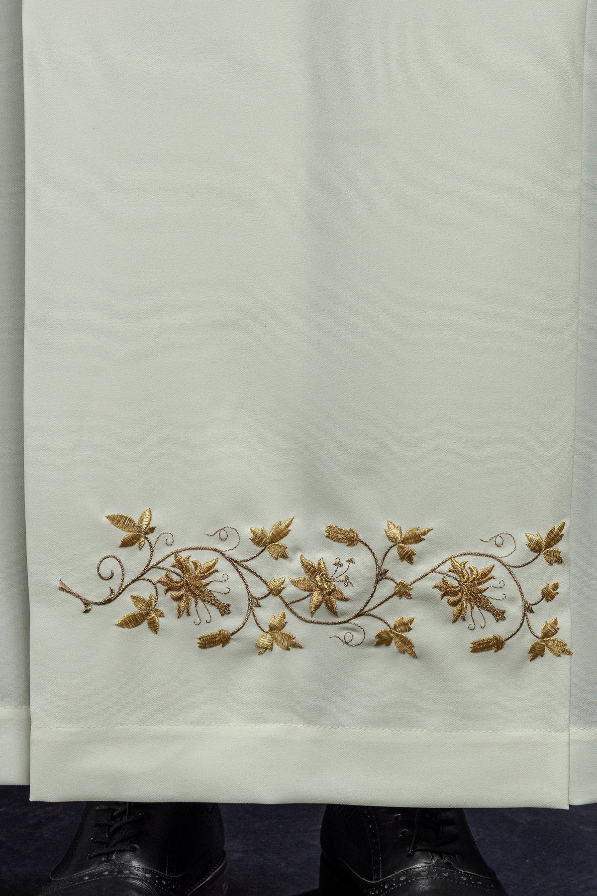 Alva sacerdotal creme, close-up do bordado floral dourado na barra
