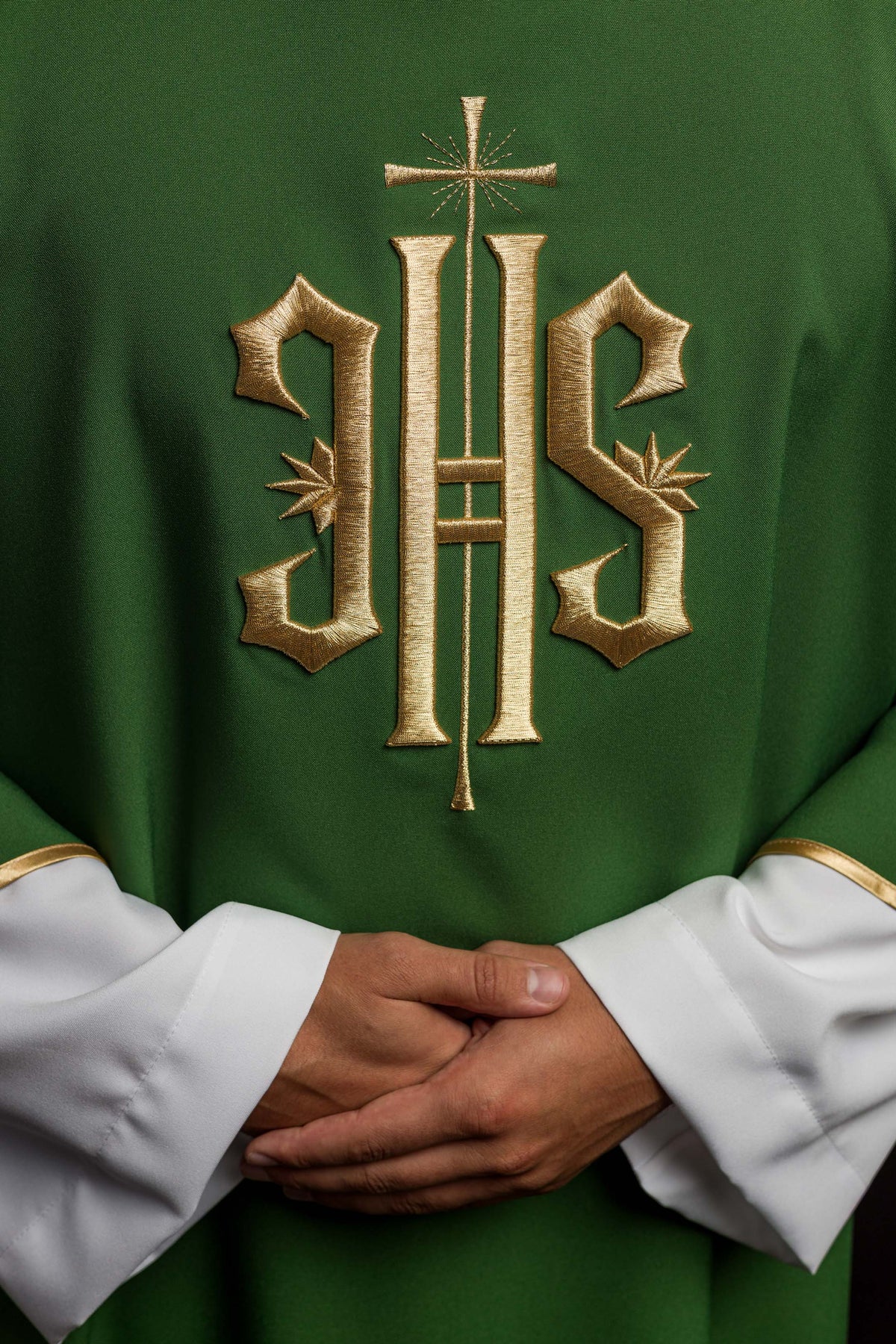 Dalmática verde com IHS bordado dourado em close-up frontal