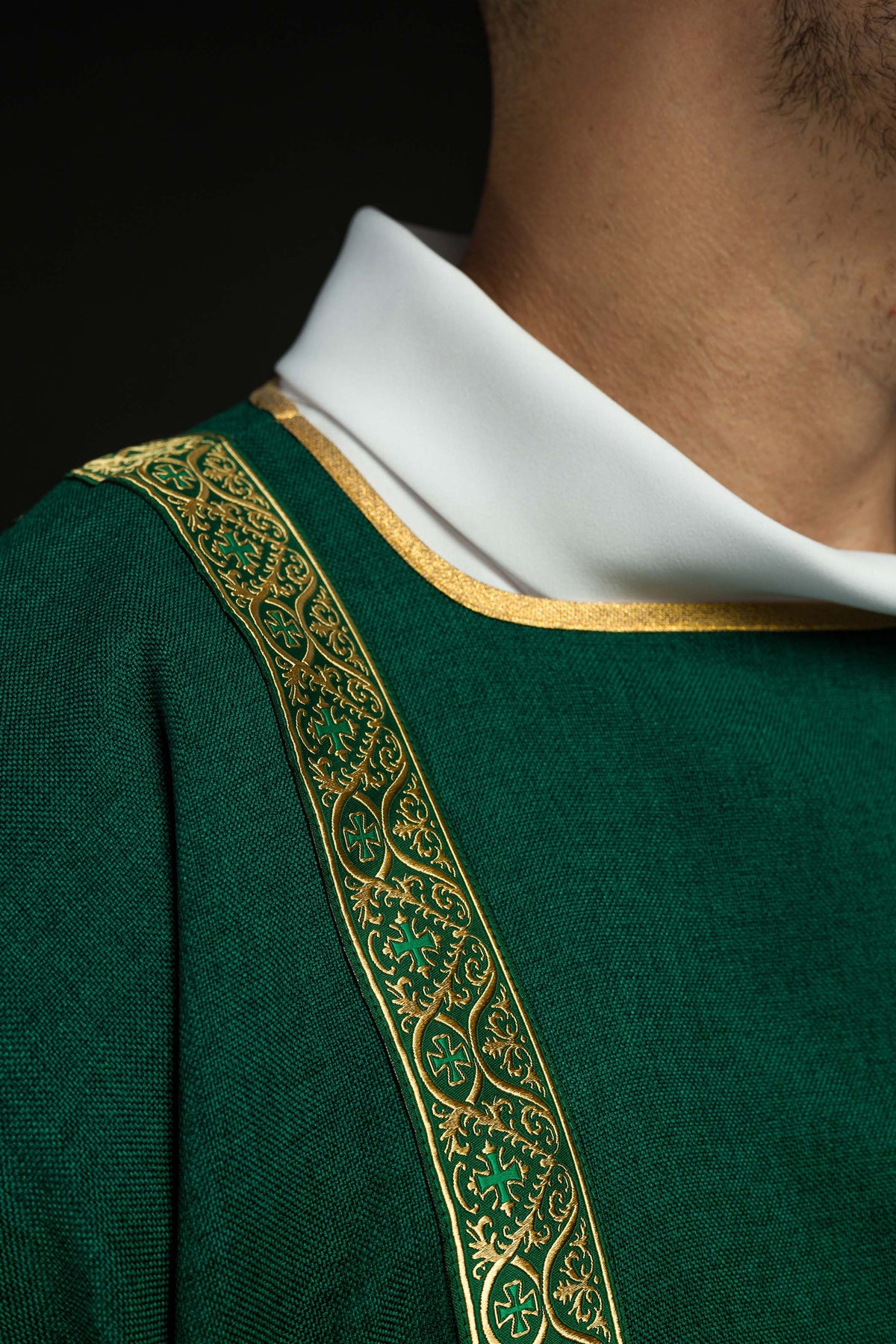 Dalmática verde com galão jacquard dourado em close no decote e ombro