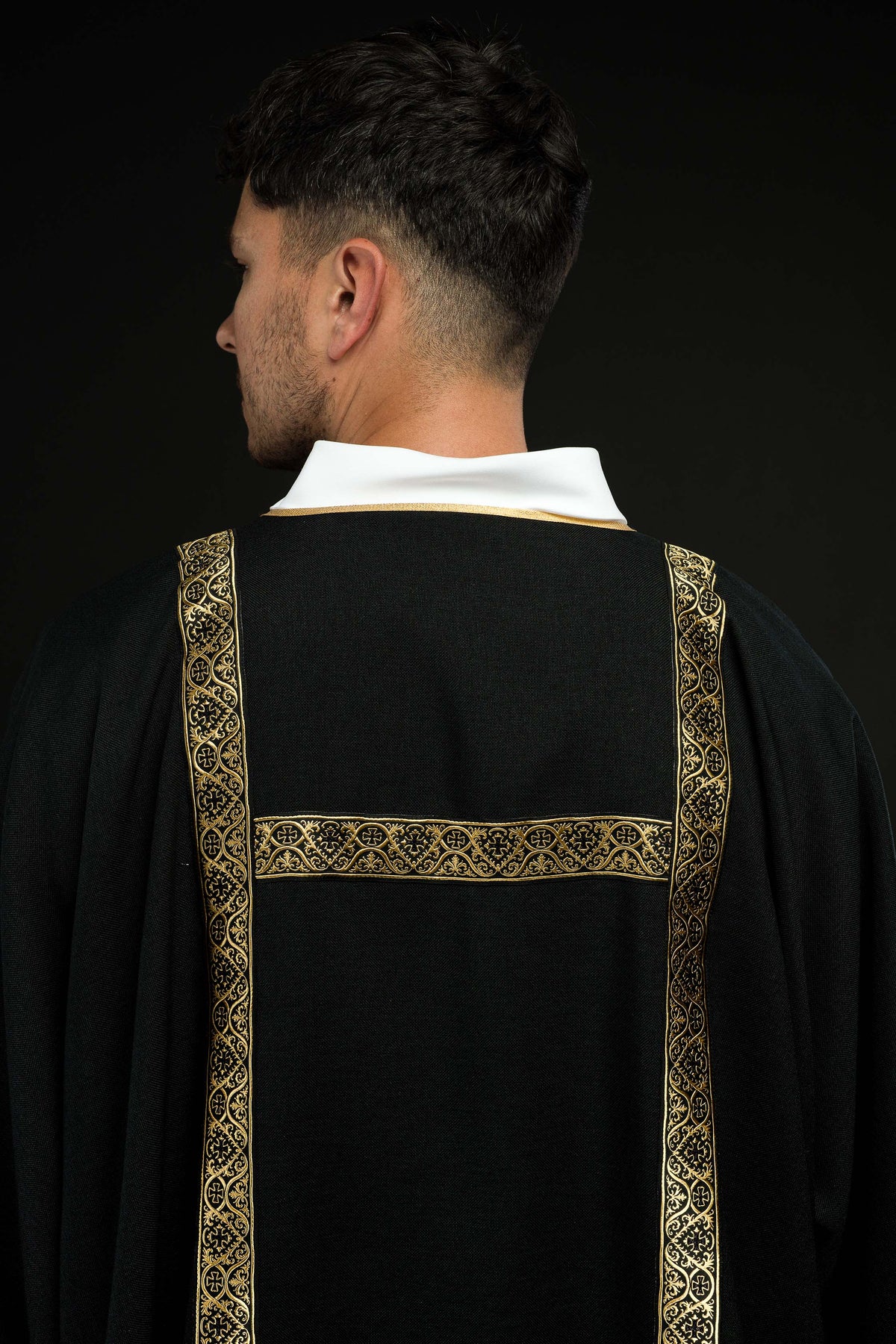 Dalmática preta com faixas de brocado dourado, vista posterior com faixa horizontal