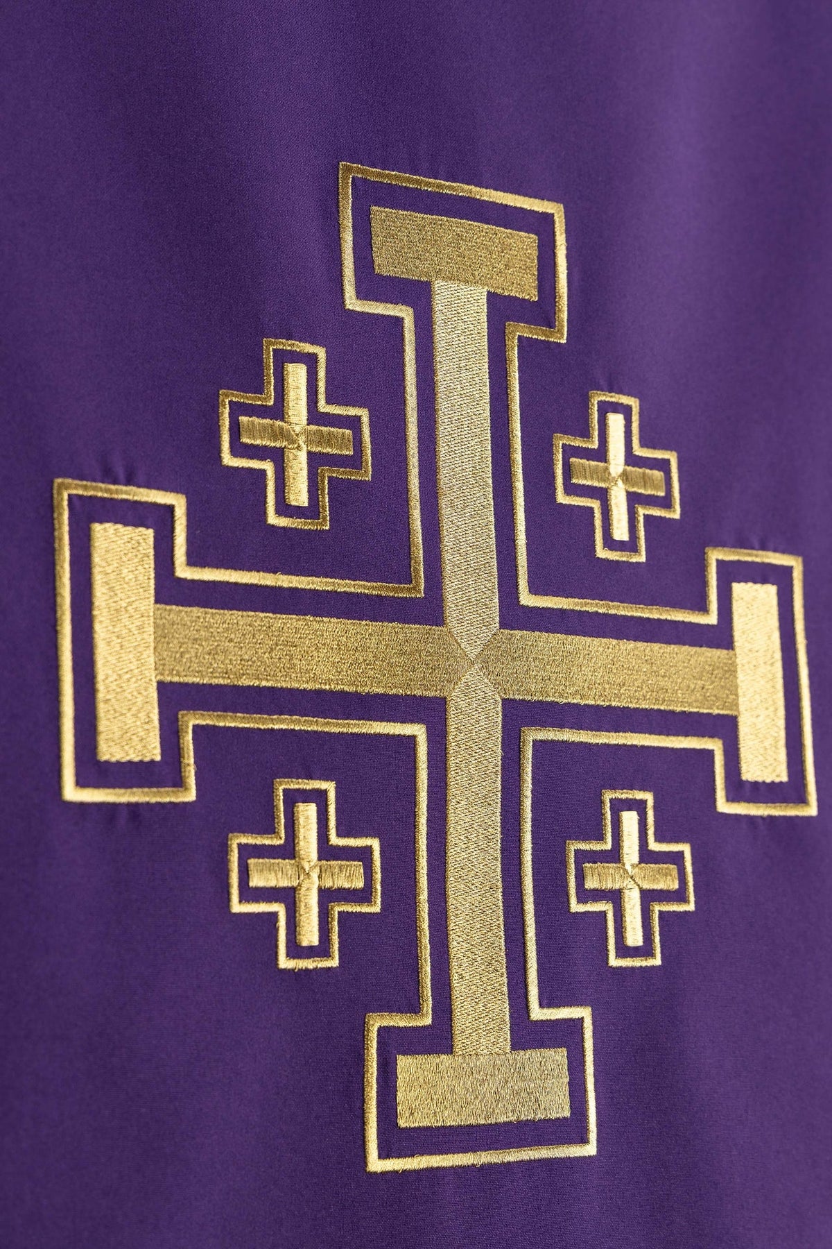 Toalha de ambão roxa em close-up do bordado dourado da Cruz de Jerusalém