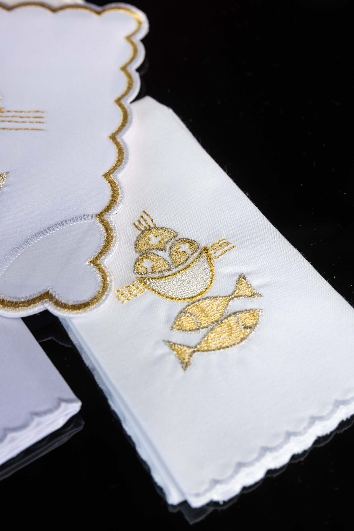 Alfaias litúrgicas Pão e Peixes, detalhe do bordado dourado em tecido branco