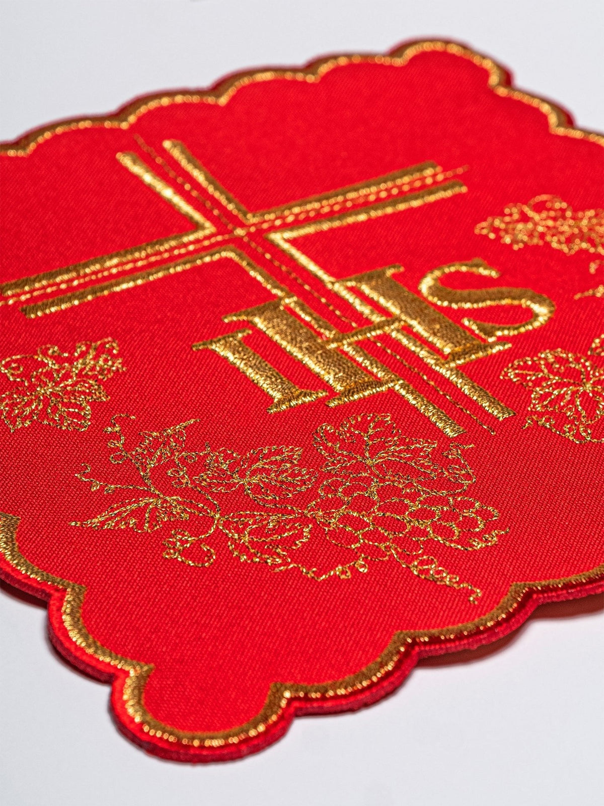 Conjunto de alfaias litúrgicas IHS, close da pala vermelha com bordado dourado de IHS, cruz e uvas