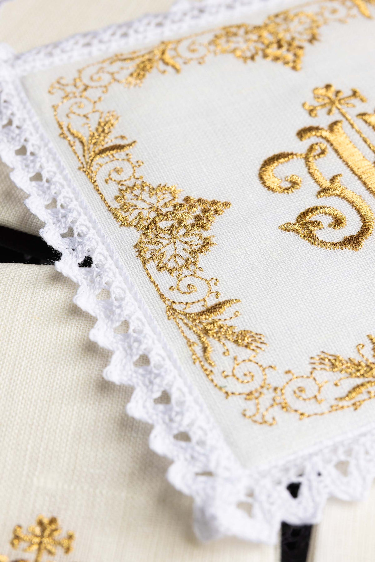Alfaias litúrgicas em linho, detalhe do bordado floral dourado e renda branca