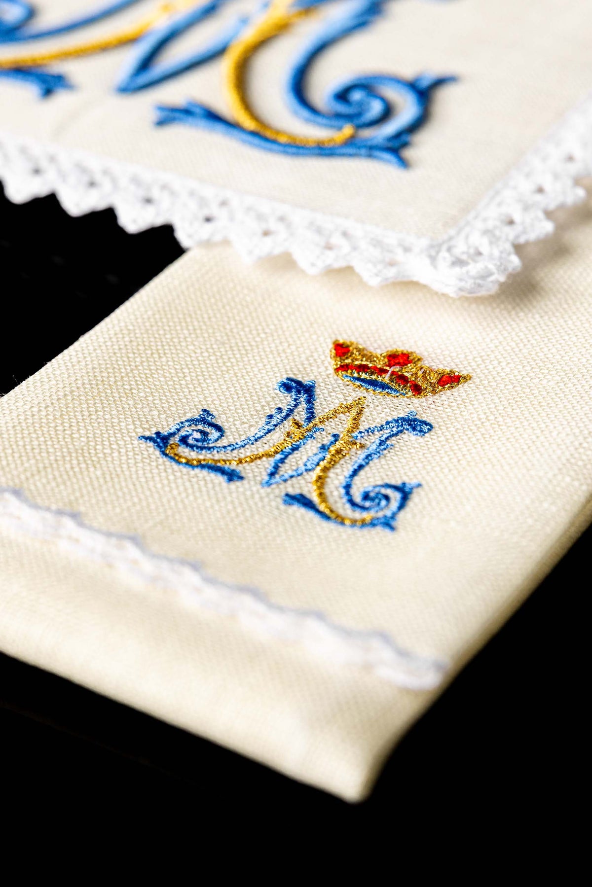 Detalhe do monograma mariano azul e dourado bordado nas alfaias litúrgicas