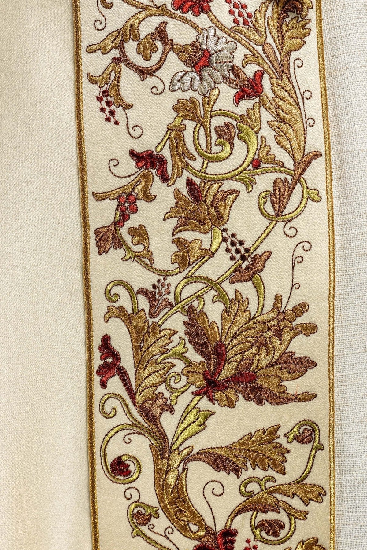 Capa de asperges creme, detalhe do bordado com folhas e flores coloridas