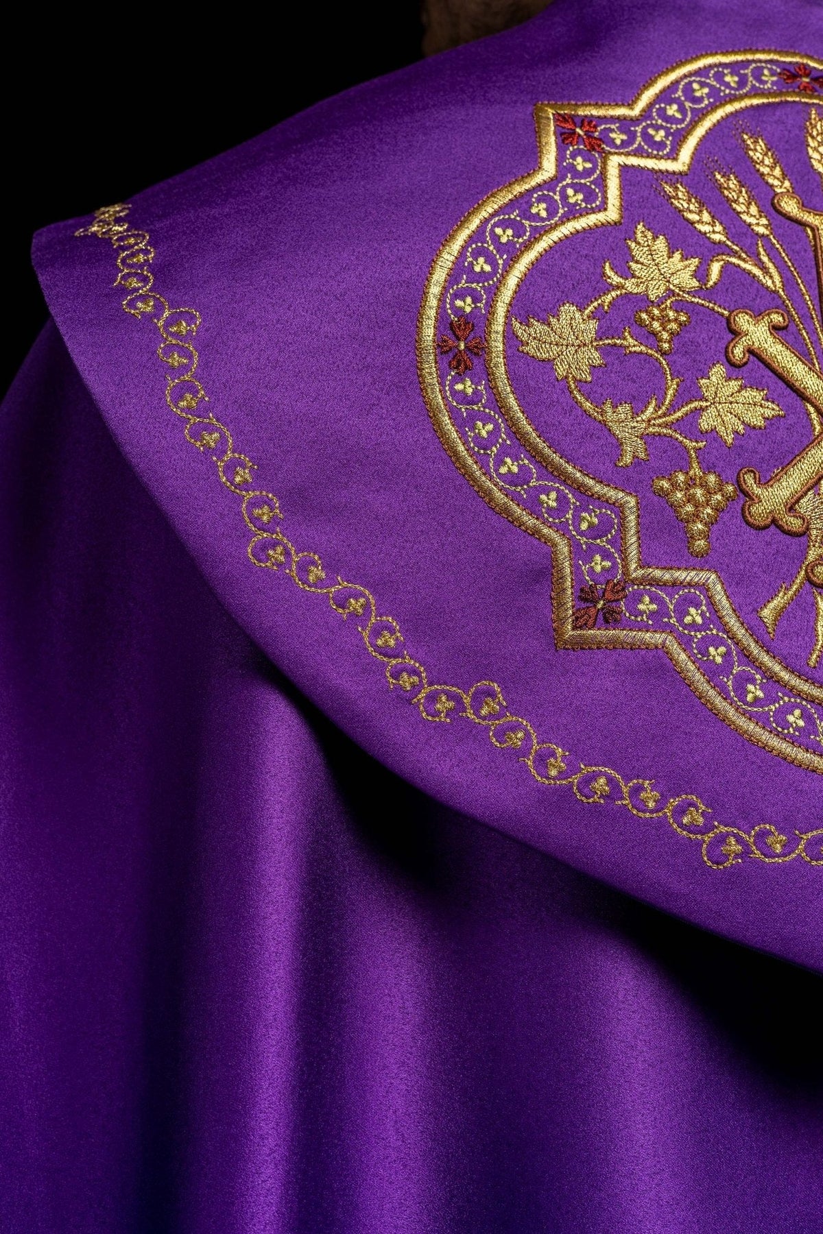 Capa de asperges roxa em detalhe lateral, com medalhão Chi-Rho e borda ornamental dourada