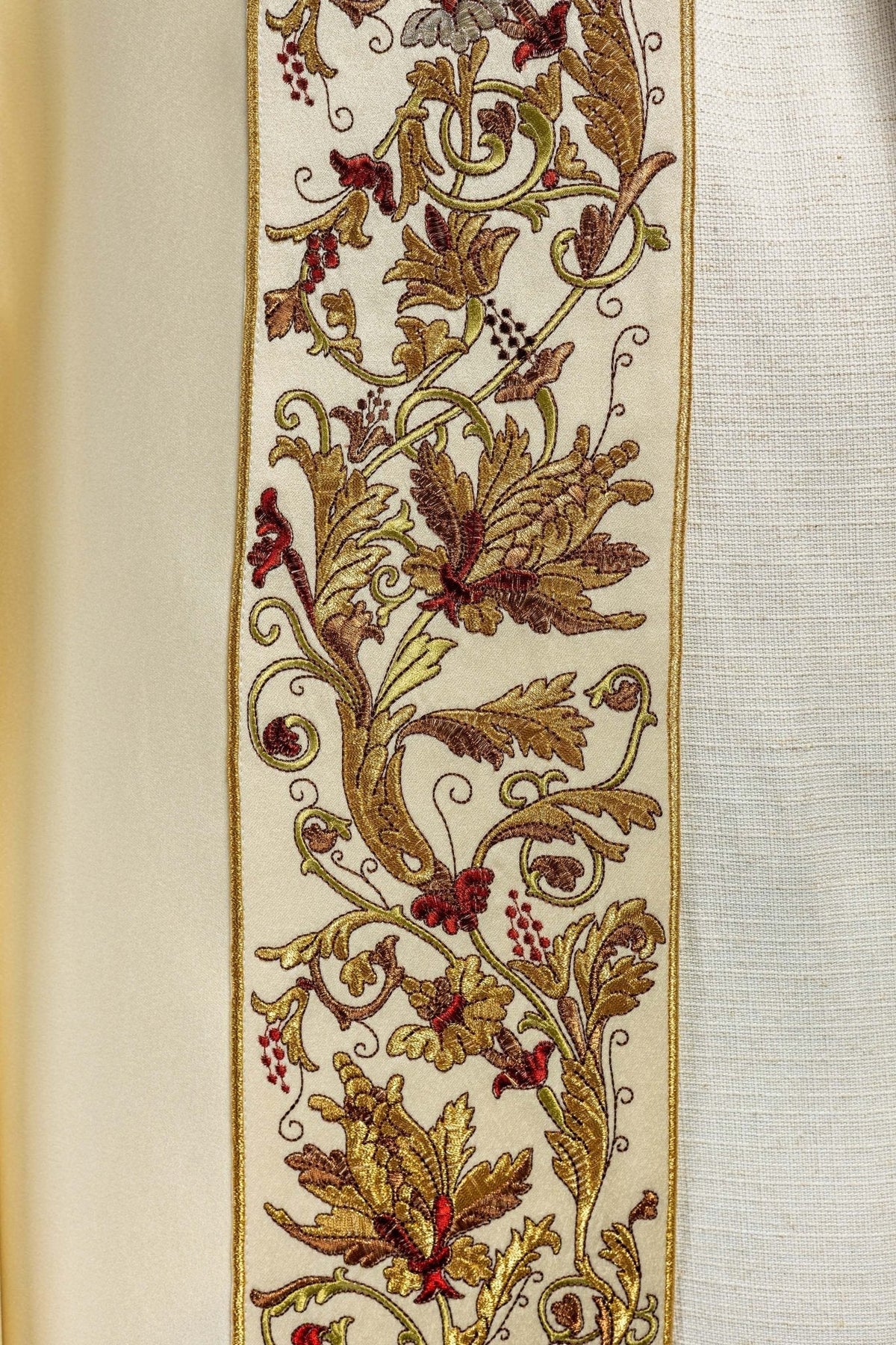 Capa de asperges creme em close, com detalhes florais e folhas bordados