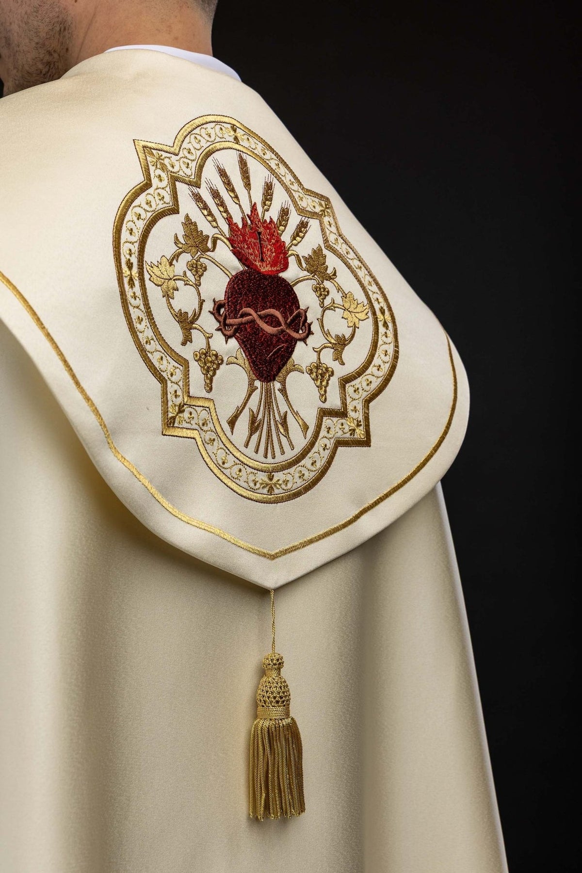 Capa de asperges litúrgica, vista posterior com borla dourada e Sagrado Coração de Jesus