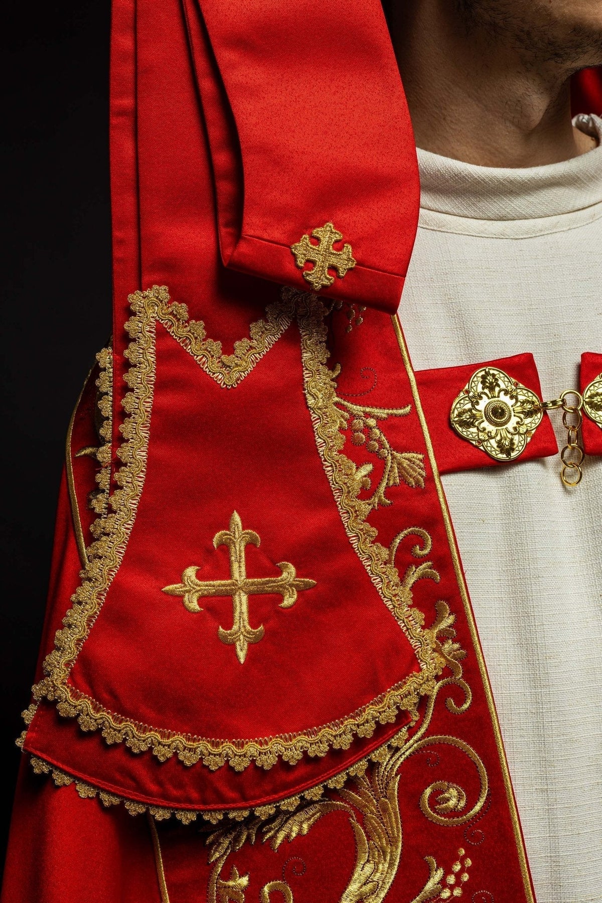 Capa de asperges romana vermelha, close-up da cruz bordada e acabamento dourado