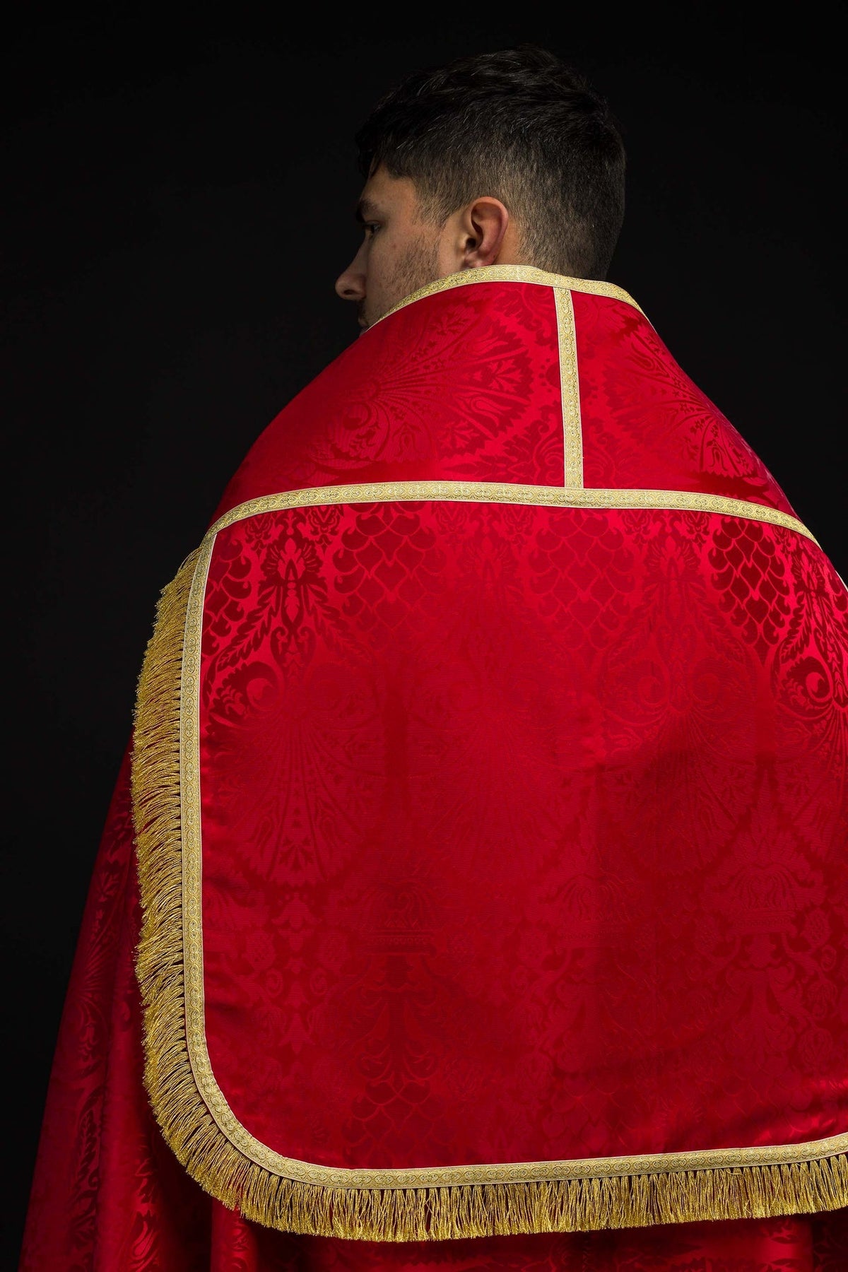 Capa de asperges vermelha vista de trás, com faixa dourada, franjas e jacquard floral