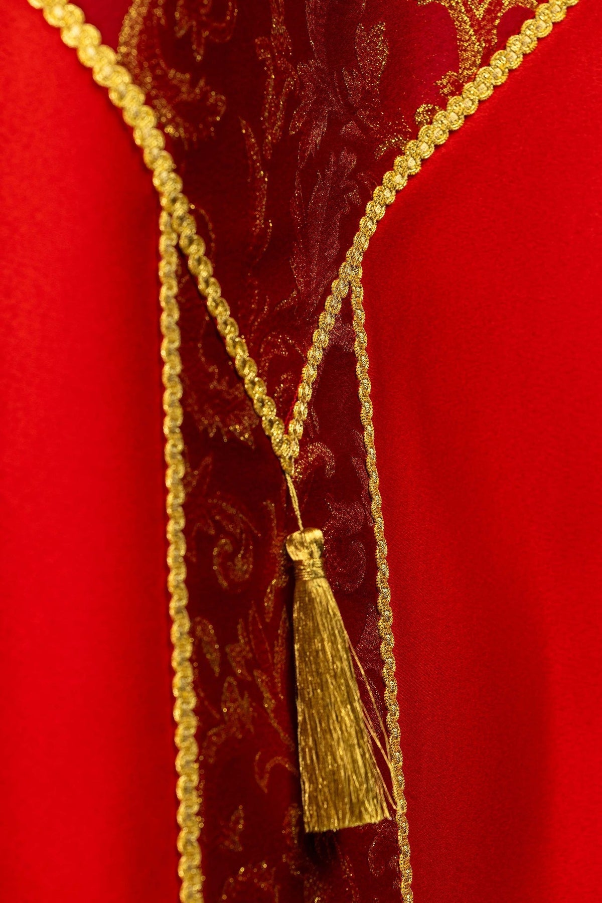 Capa de asperges vermelha em detalhe, mostrando tecido jacquard floral e galão dourado