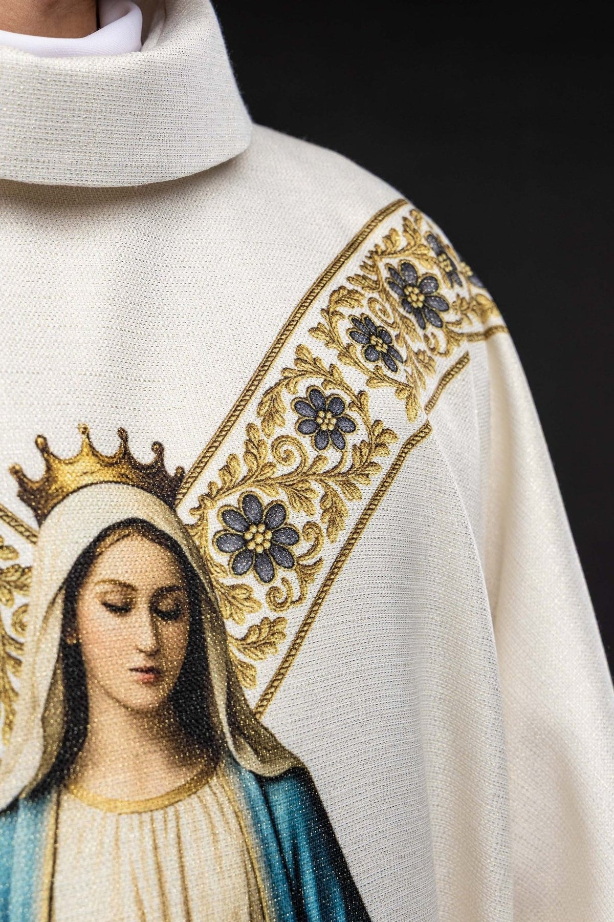 Casula em close-up com imagem de Nossa Senhora e galão floral dourado