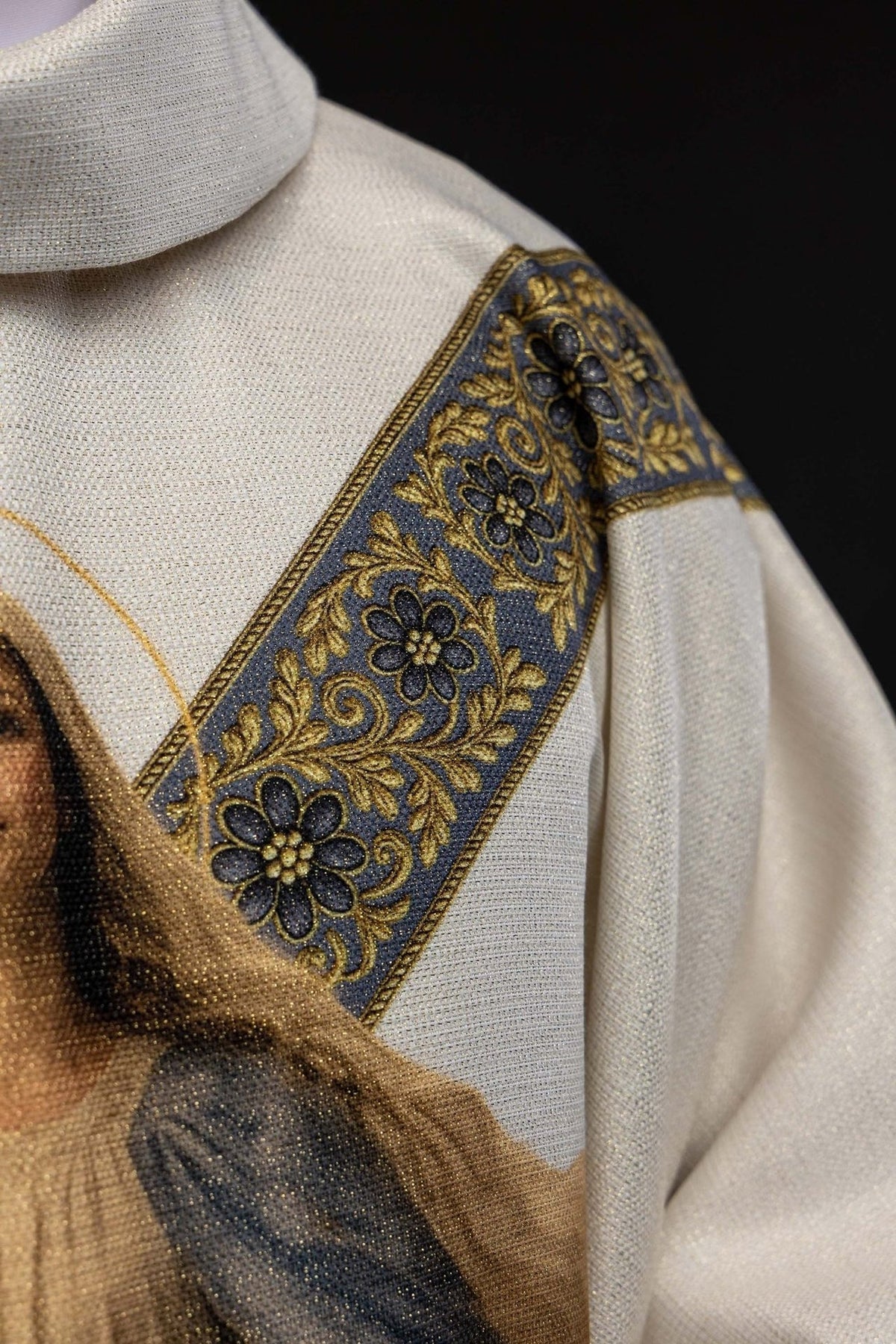 Casula mariana em vista frontal, com gola alta, galão floral e viés dourado