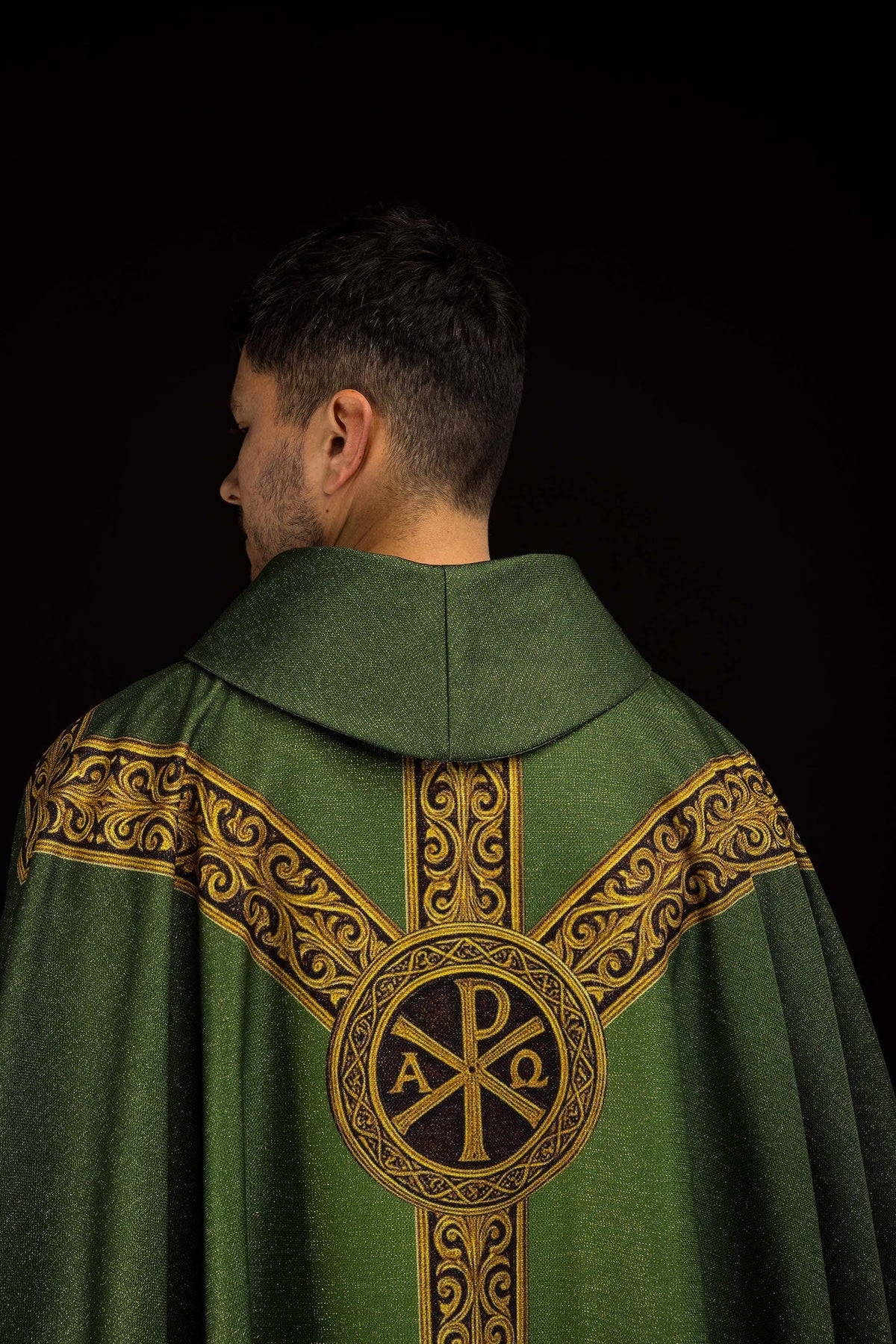 Casula Pax verde vista de costas, com medalhão PX e faixas douradas ornamentadas