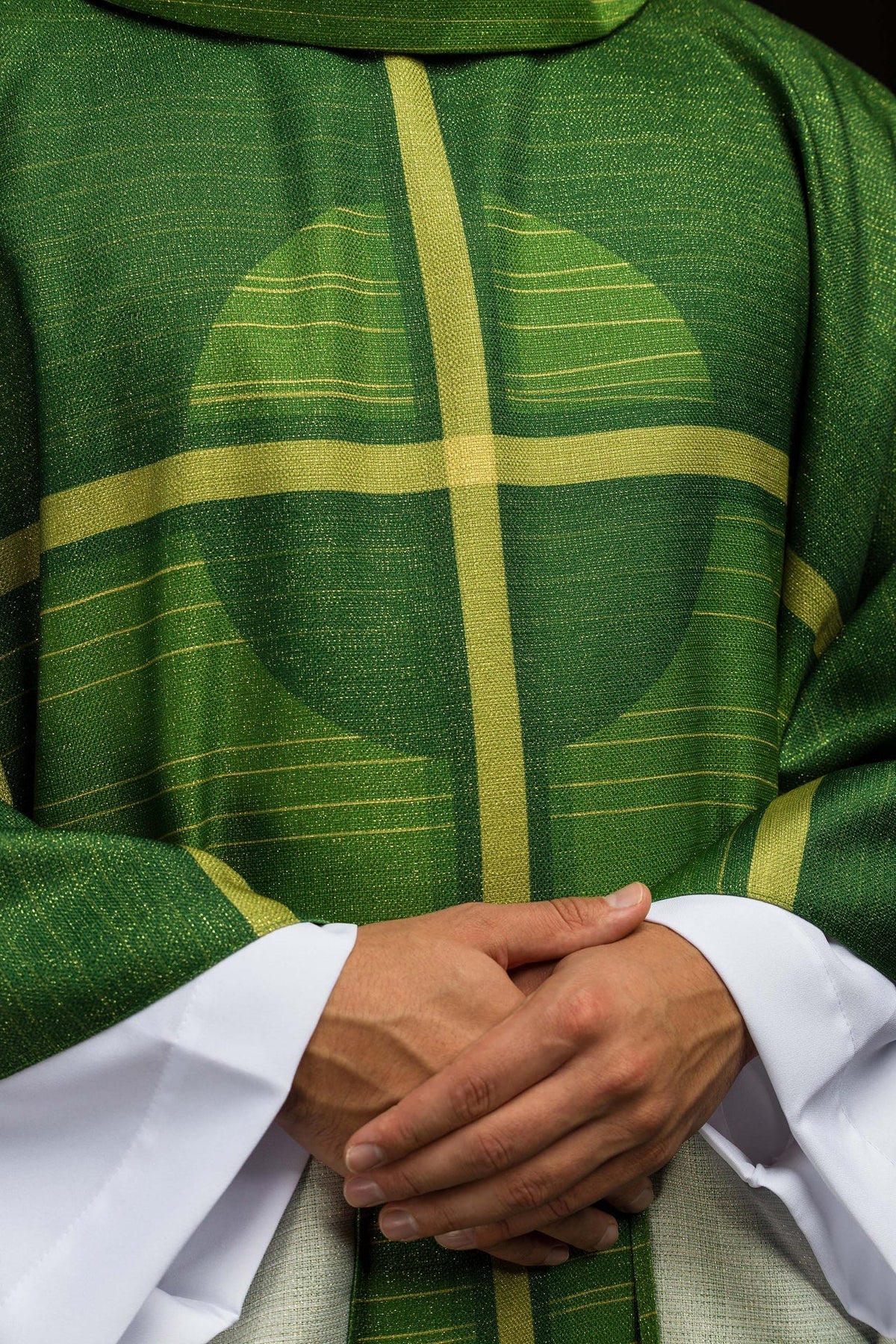 Casula verde com motivo de cruz em close-up frontal, com tecido de linhas douradas