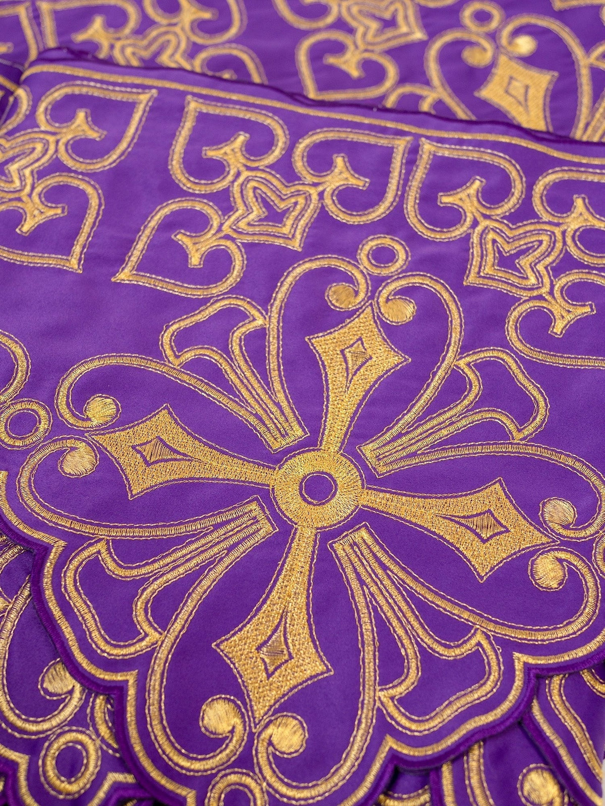 Tecido para toalha de altar roxo em close, com bordado dourado de rosetas e arabescos