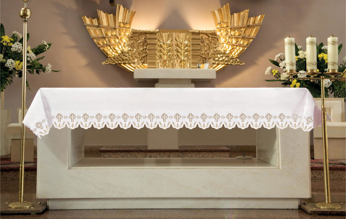 Toalha de altar com bordado frontal de cruzes, IHS e espigas, branca, vista frontal sobre o altar
