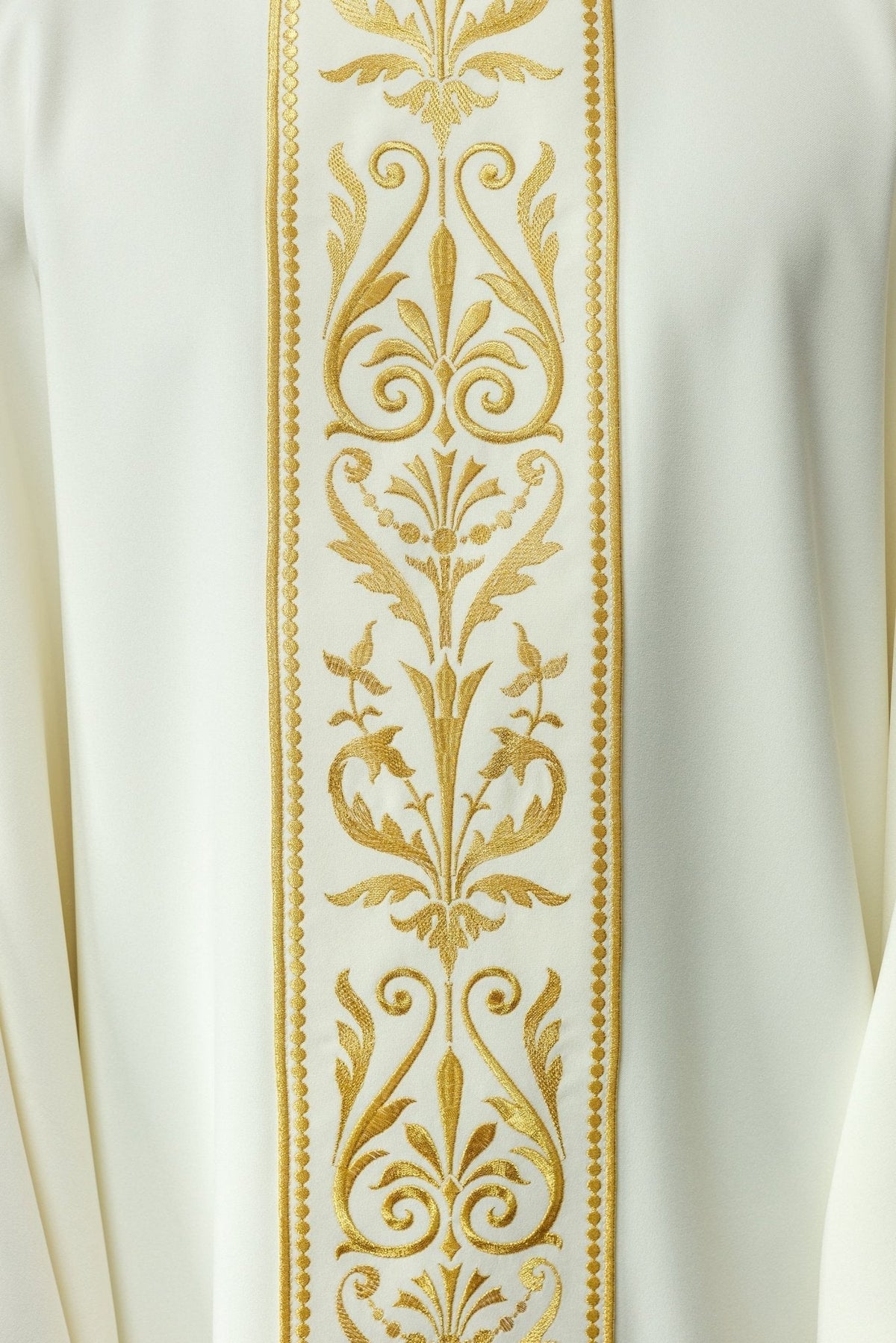 Casula creme em close-up, com faixa central de arabescos e flores bordados em dourado