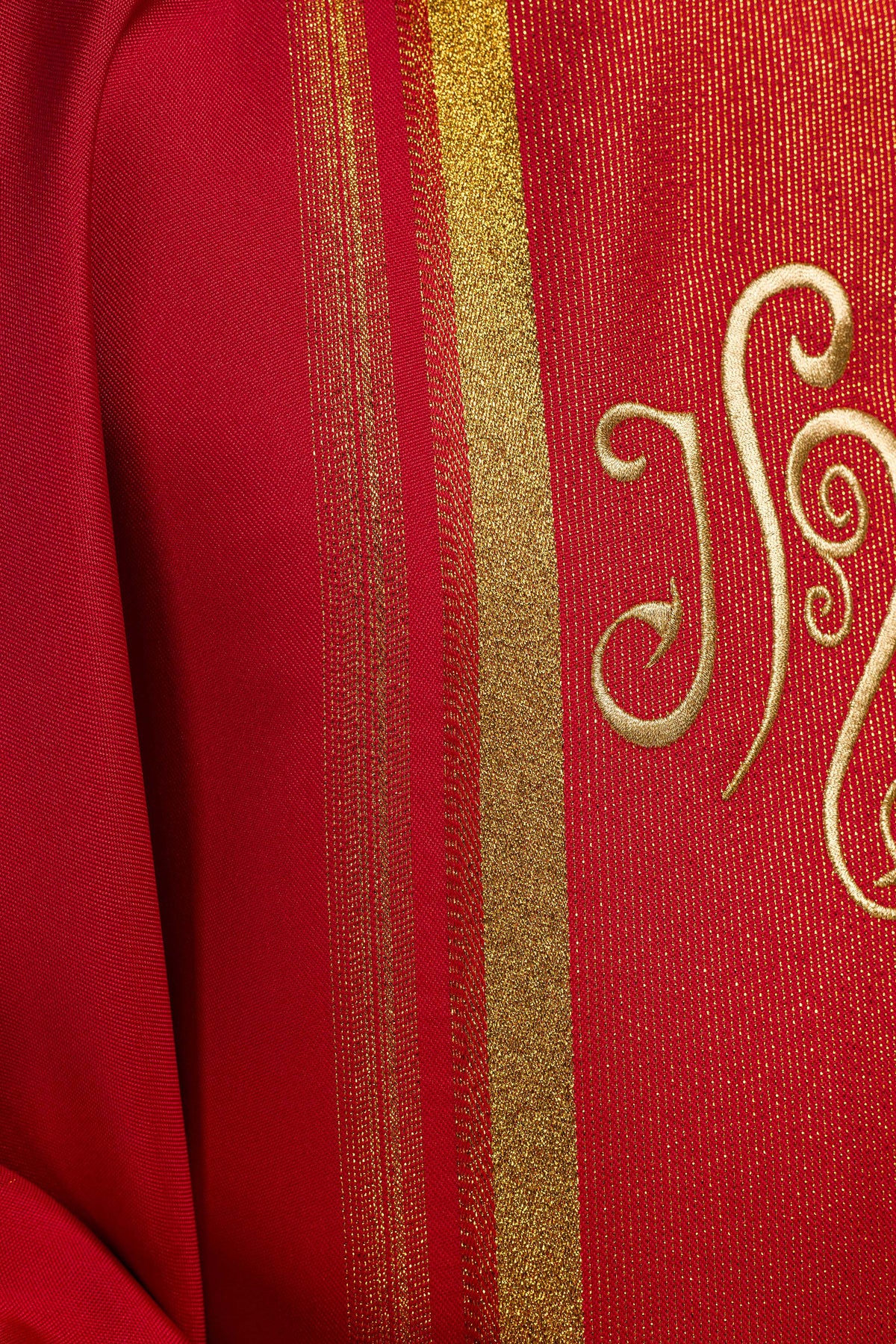 Casula vermelha com close-up do bordado IHS e das faixas douradas