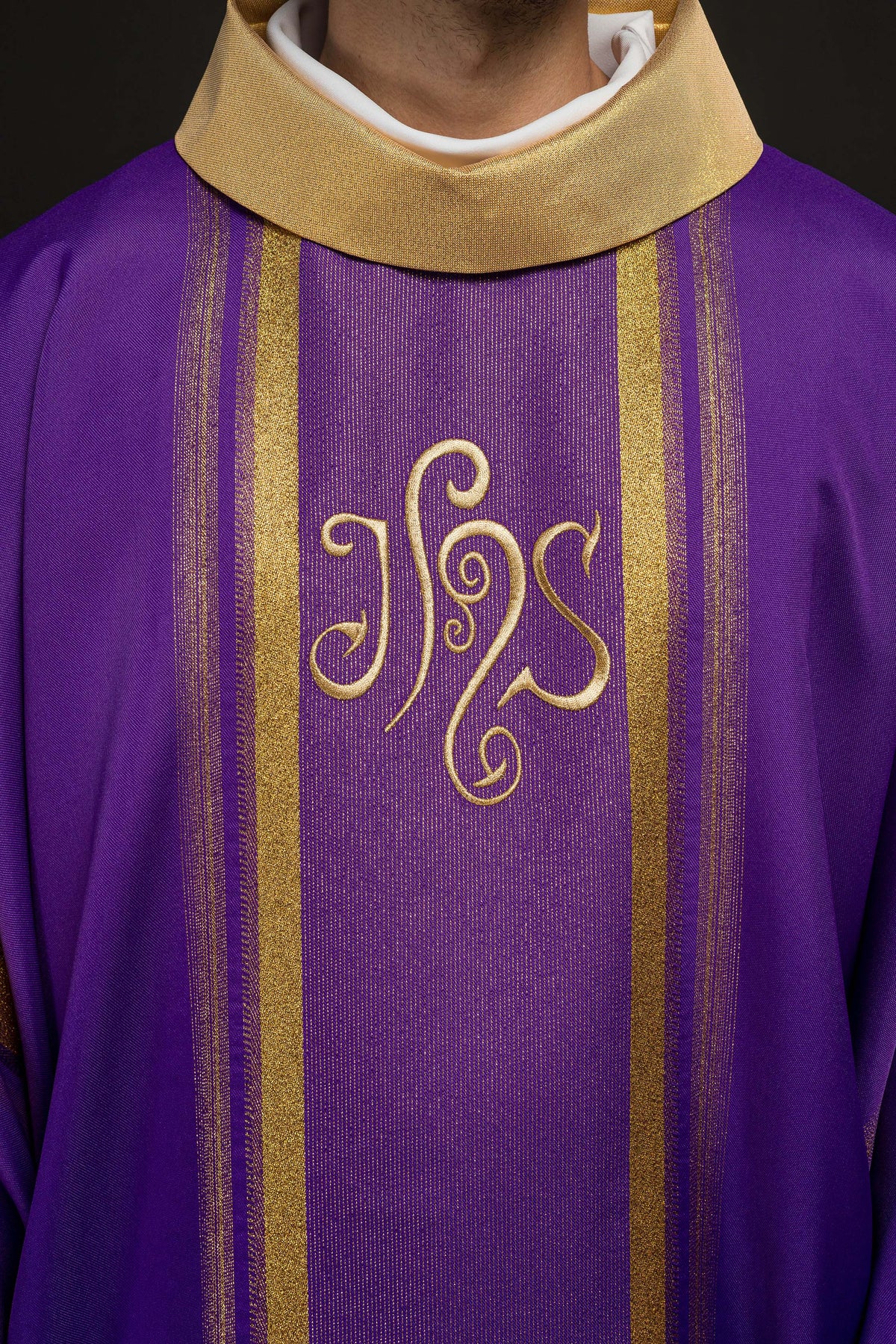 Casula roxa com símbolo IHS, close frontal das faixas e bordado dourado