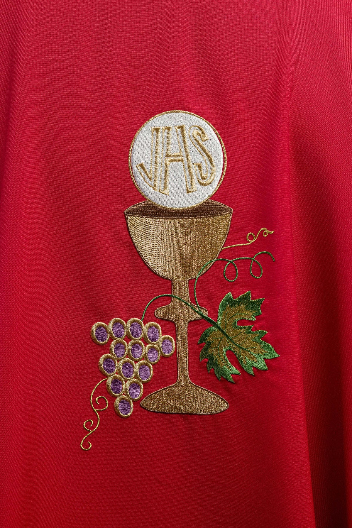 Casula vermelha com cálice, uvas e folhas bordados em close-up frontal