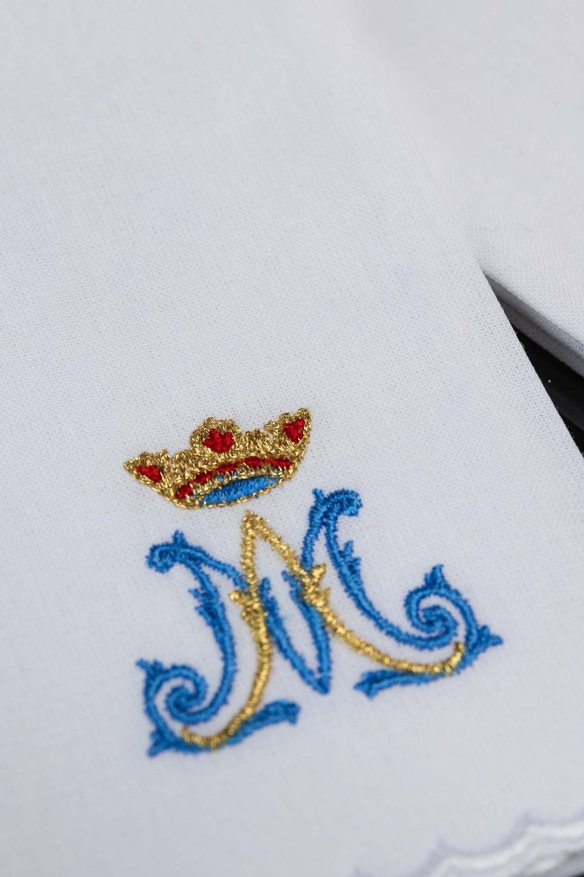 Sanguíneo litúrgico branco em close-up, com motivo mariano bordado em azul e dourado