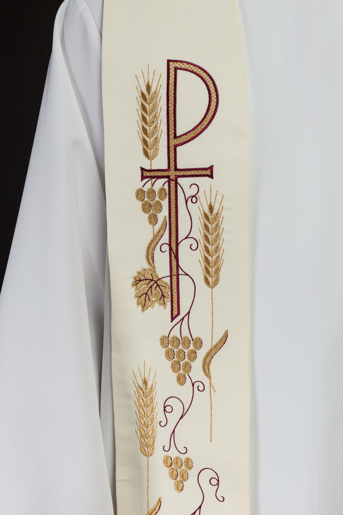 Estola sacerdotal creme em close, destacando a cruz, cachos de uvas e espigas bordados