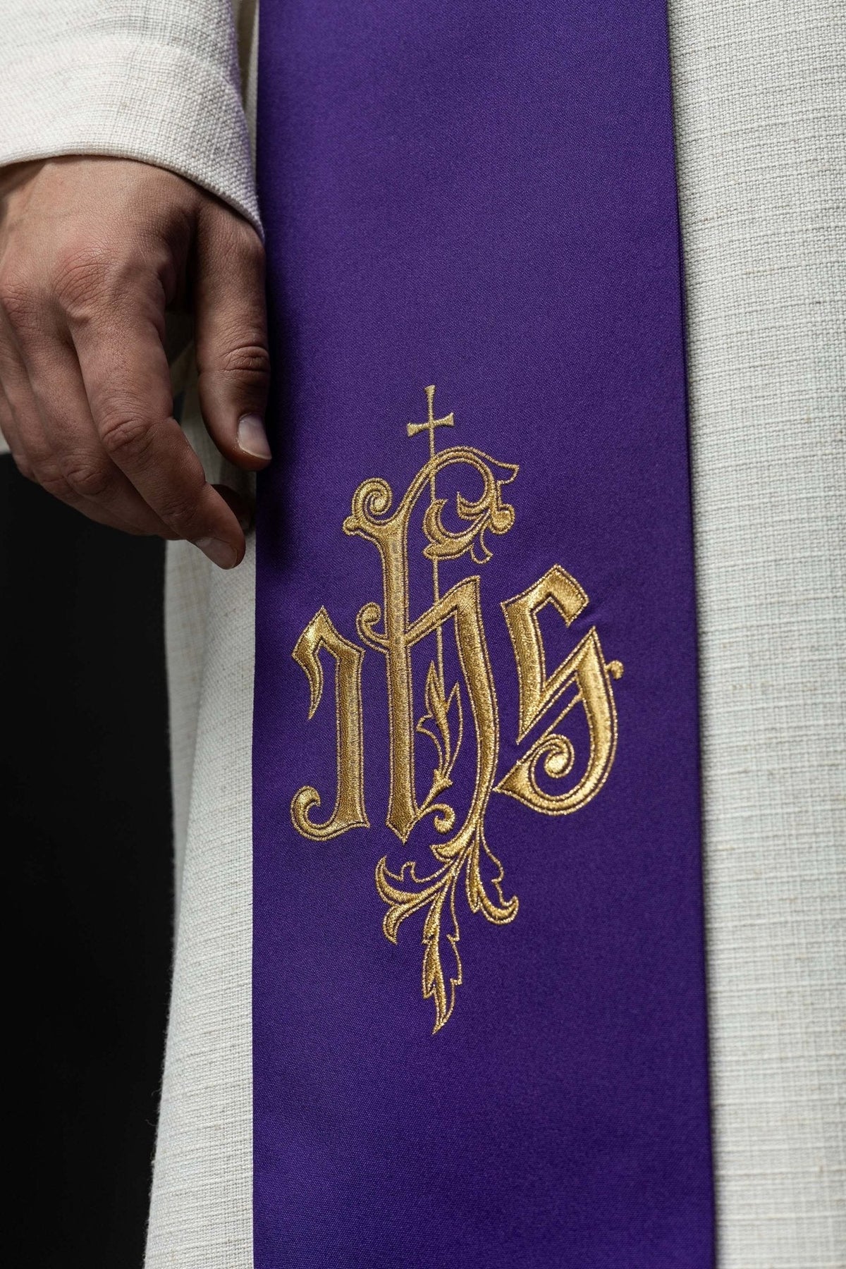 Estola bordada IHS roxa em close-up, com bordado IHS dourado e cruz