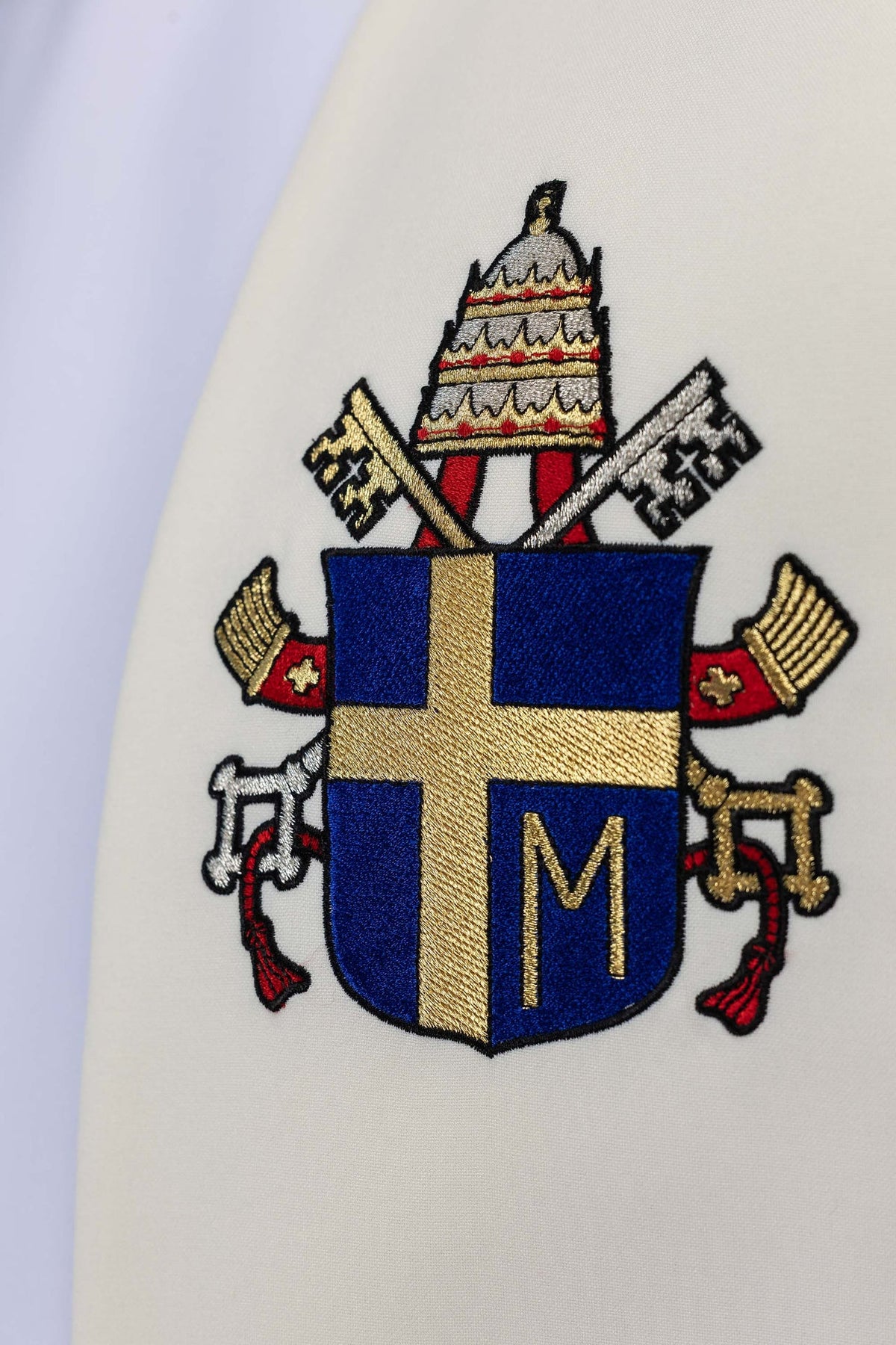 Estola marfim ecru, close-up do brasão papal bordado