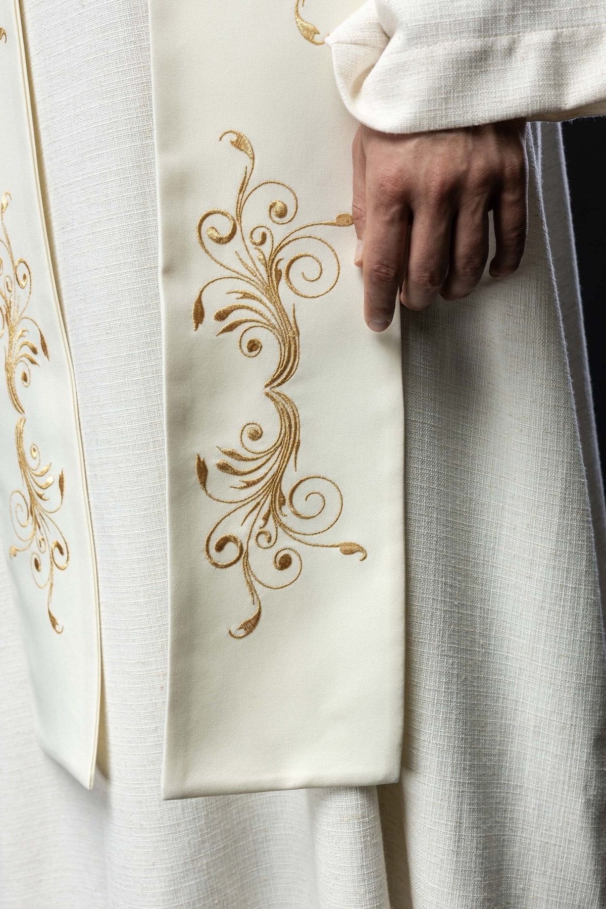 Estola creme com IHS, detalhe do bordado arabesco dourado próximo à ponta