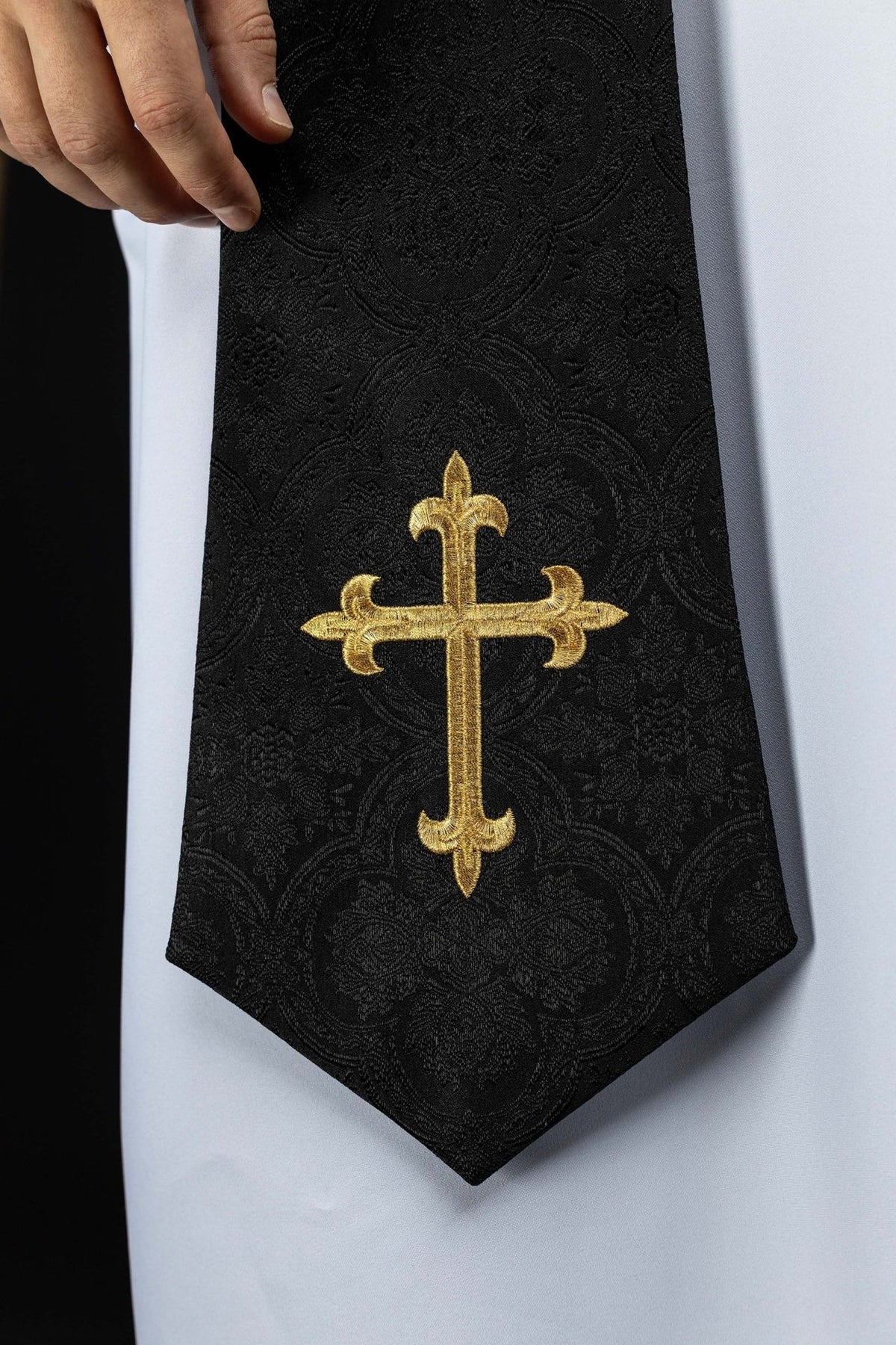Estola sacerdotal preta em tecido jacquard, close-up do bordado de cruz dourada