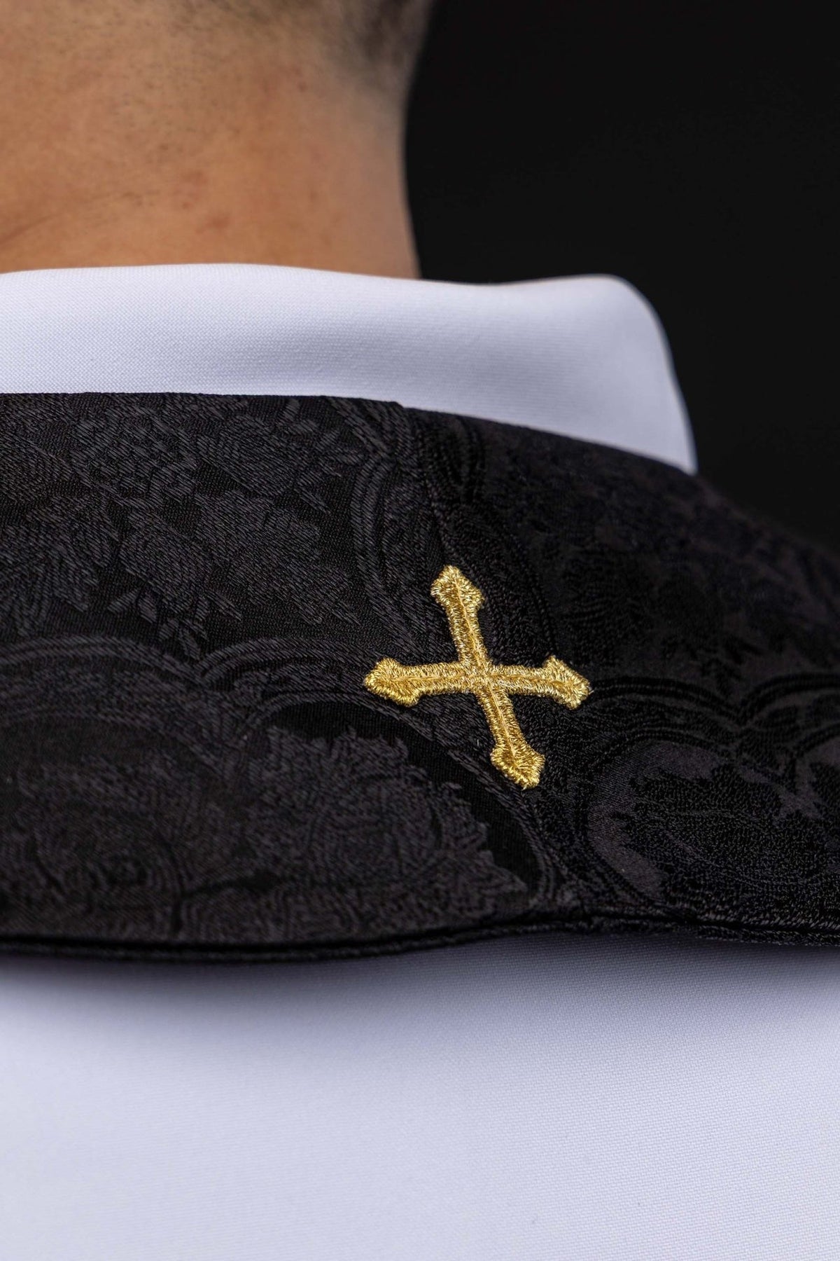 Estola sacerdotal preta em tecido jacquard, close-up da cruz dourada bordada