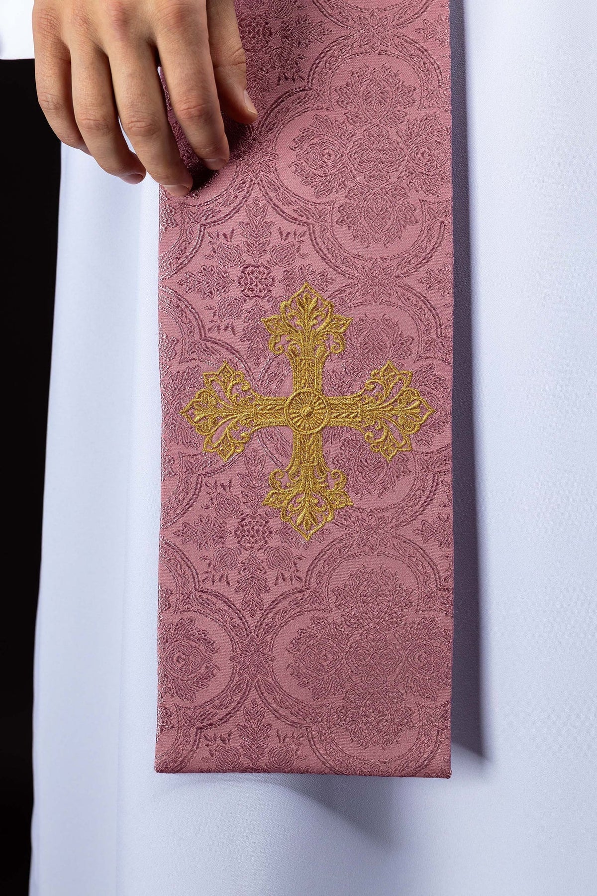 Estola rosa em jacquard com cruz dourada bordada, close-up frontal