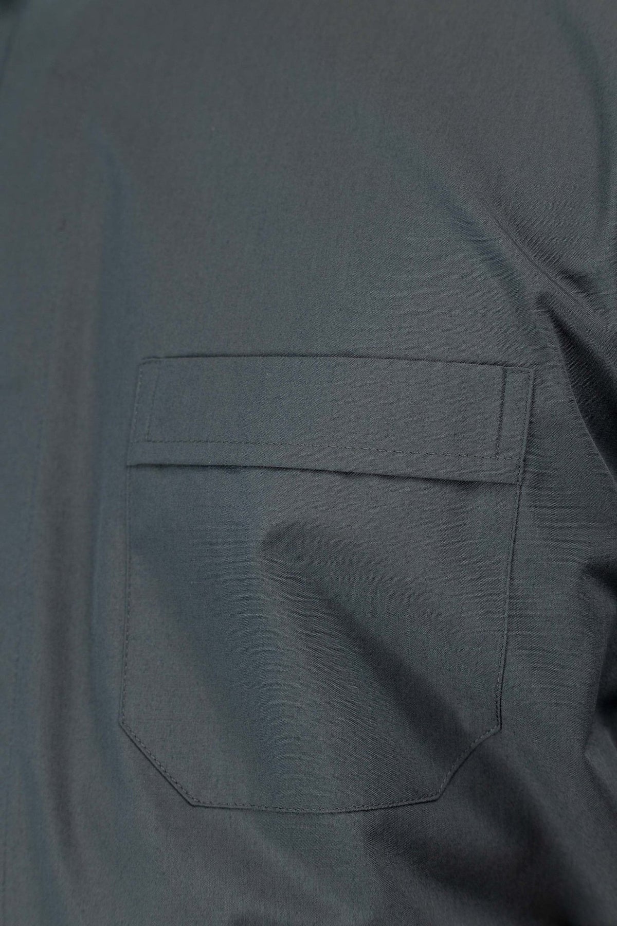 Camisa clerical cinza-escura com bolso frontal de aba e canto inferior chanfrado