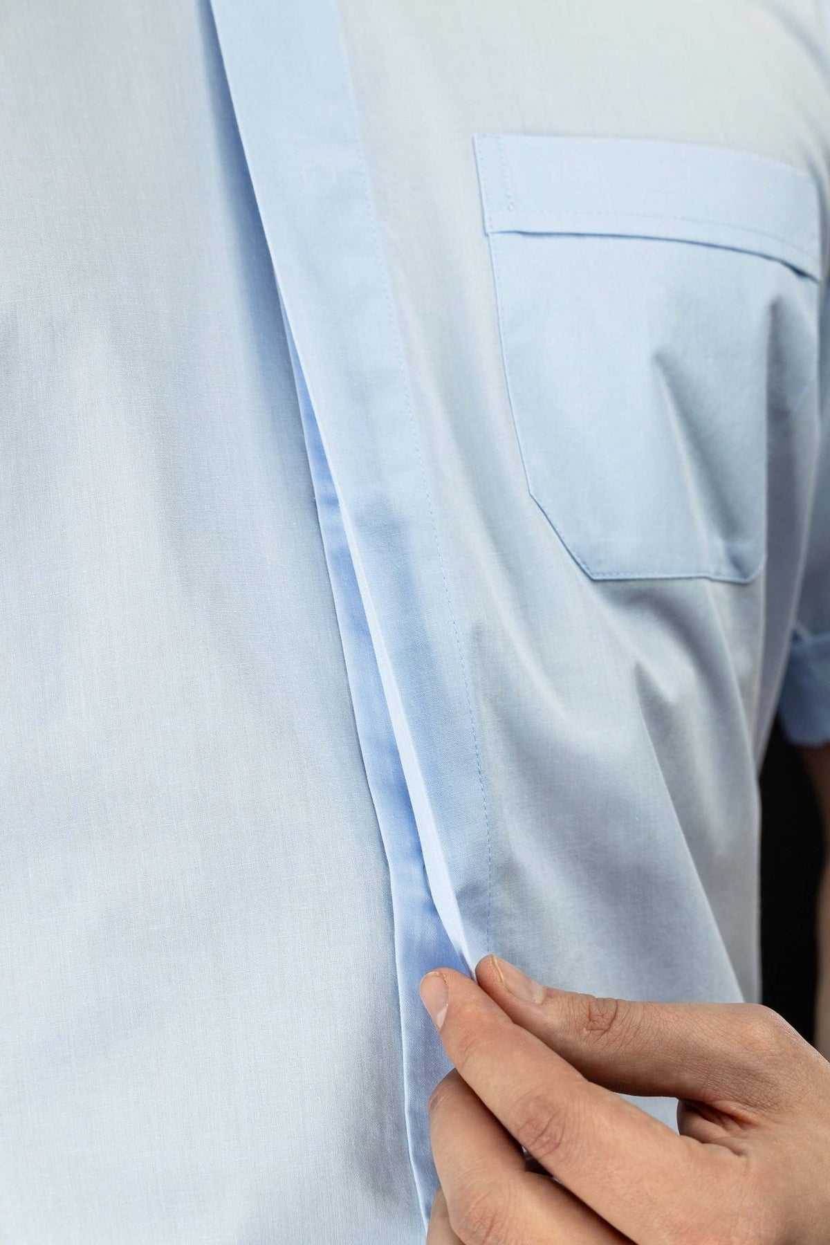 Camisa clerical azul-clara em close-up da vista frontal, com carcela e bolso