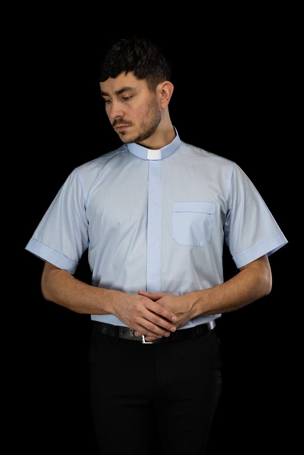 Camisa clerical azul-clara de manga curta vista de frente, com colarinho clerical e bolso